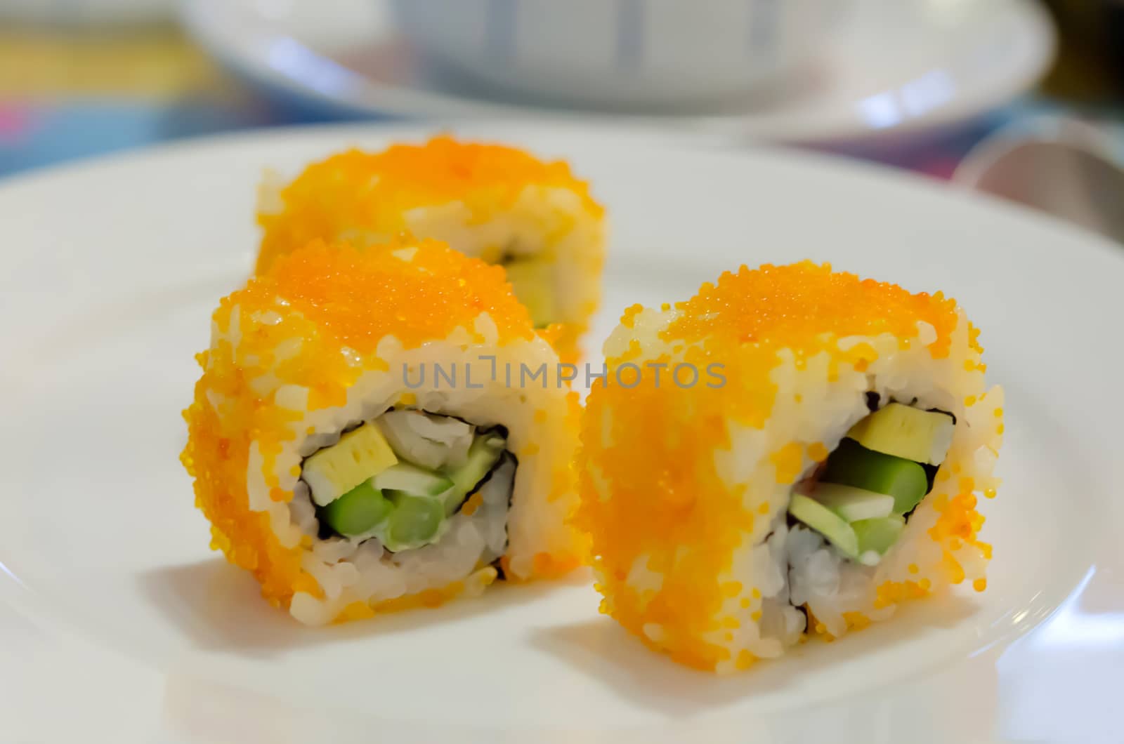 California Maki Sushi with Masago , Roll made of Crab Meat, Avocado, Cucumber, Japanese Mayonnaise inside. smelt roe outside on dish