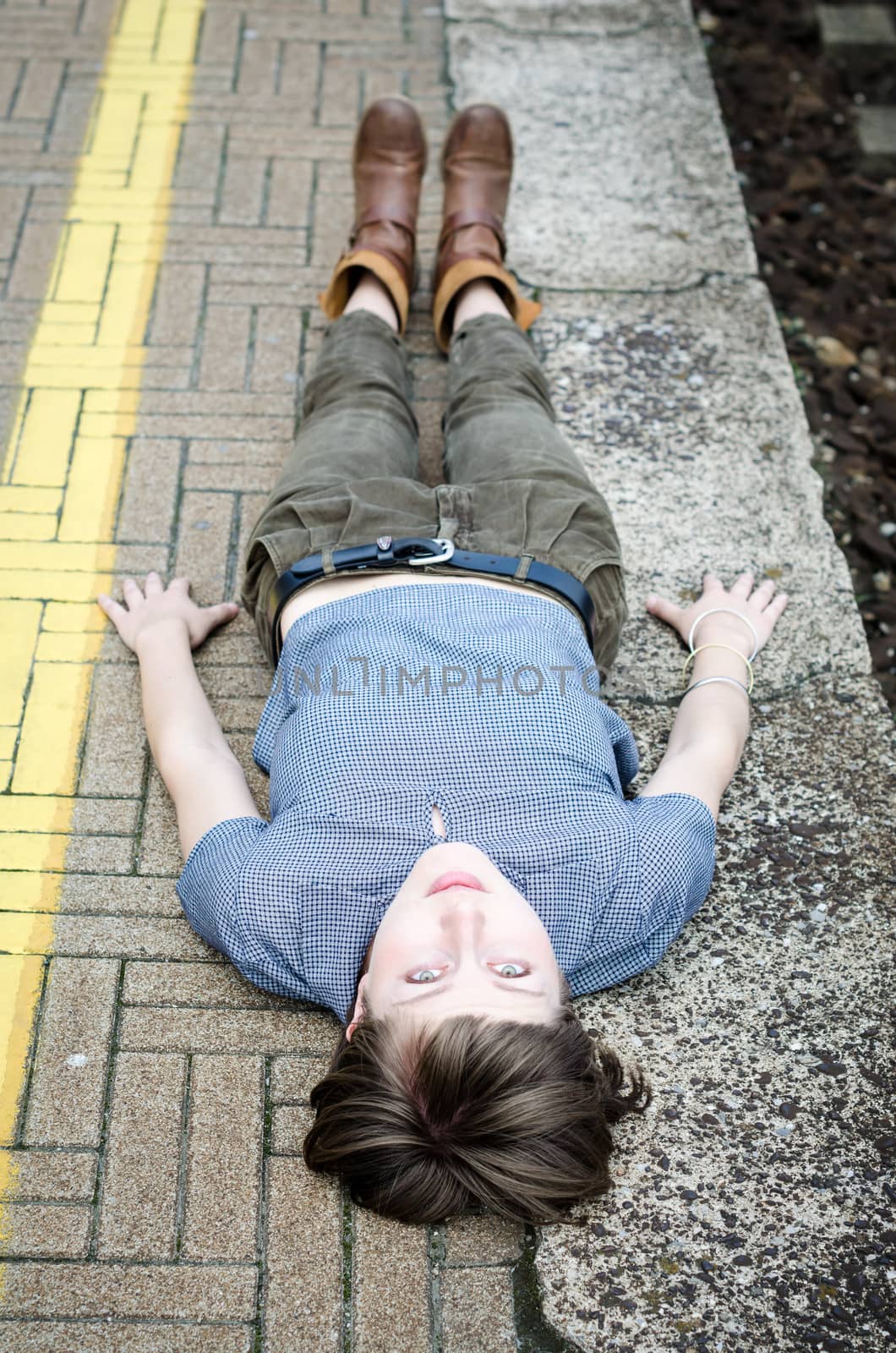 young beautiful hipster woman lying on the ground in the city