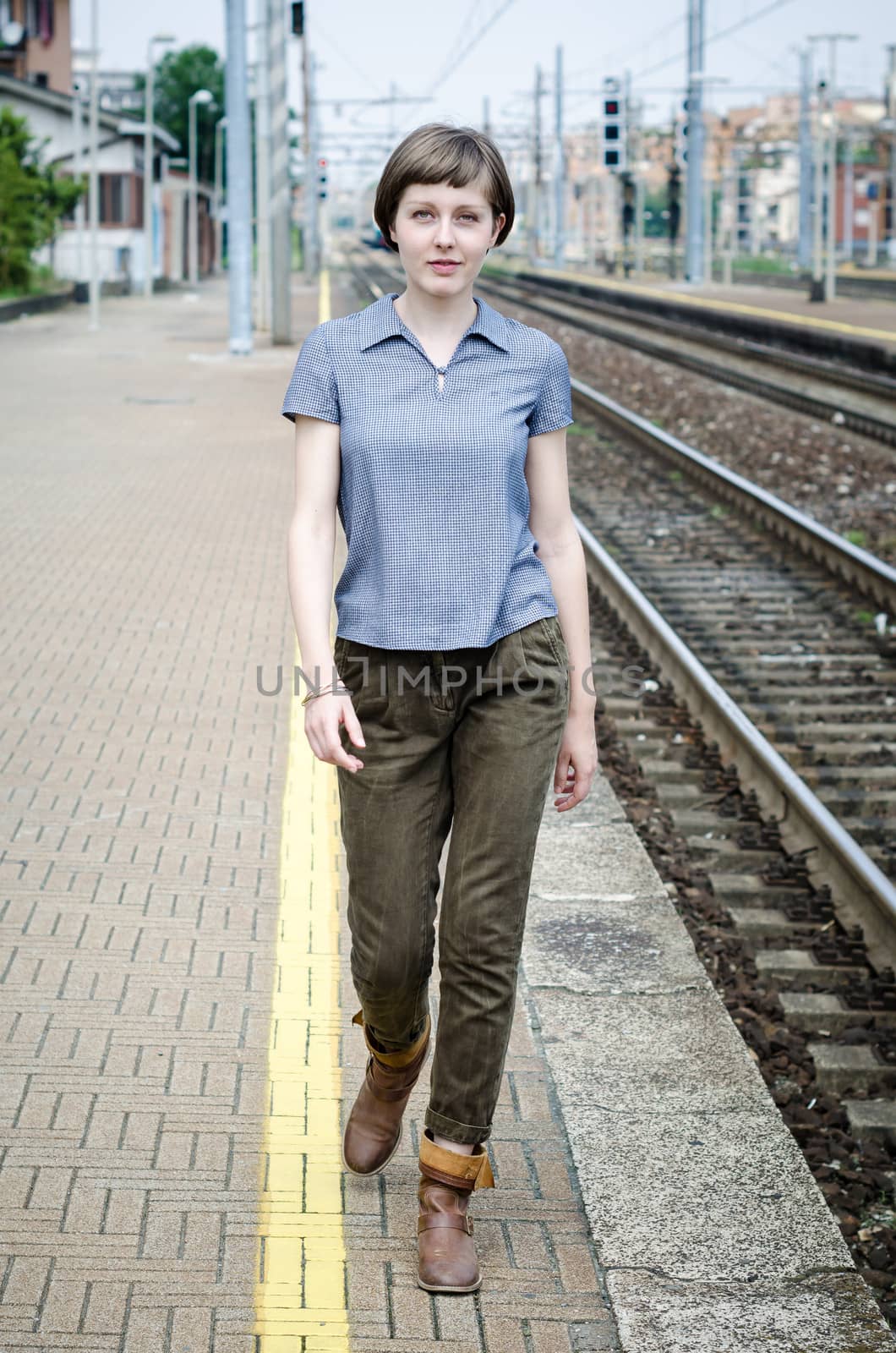 young beautiful hipster woman walking in a railway station