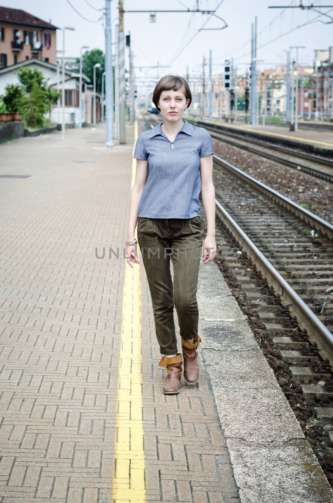 young beautiful hipster woman walking in a railway station