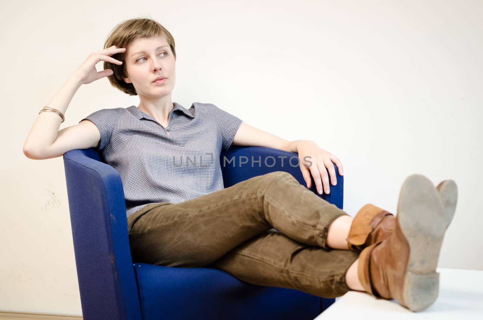 young beautiful hipster woman sitting in the armchair relaxing at home
