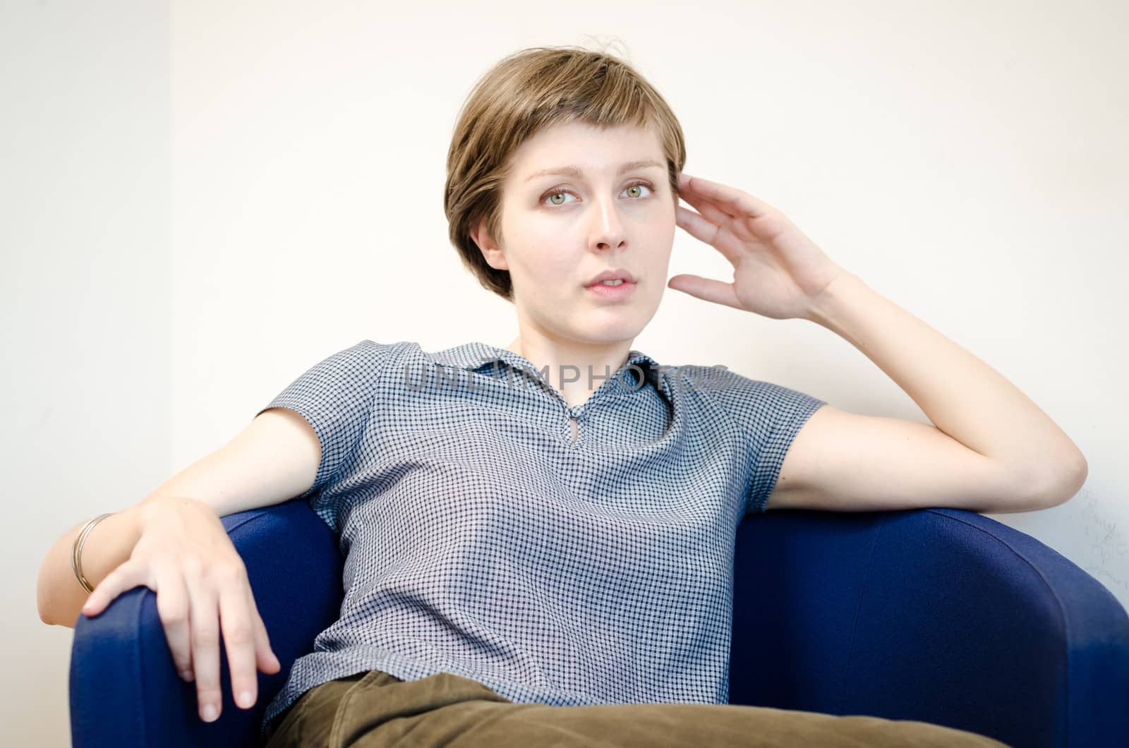 young beautiful hipster woman sitting in the armchair relaxing at home