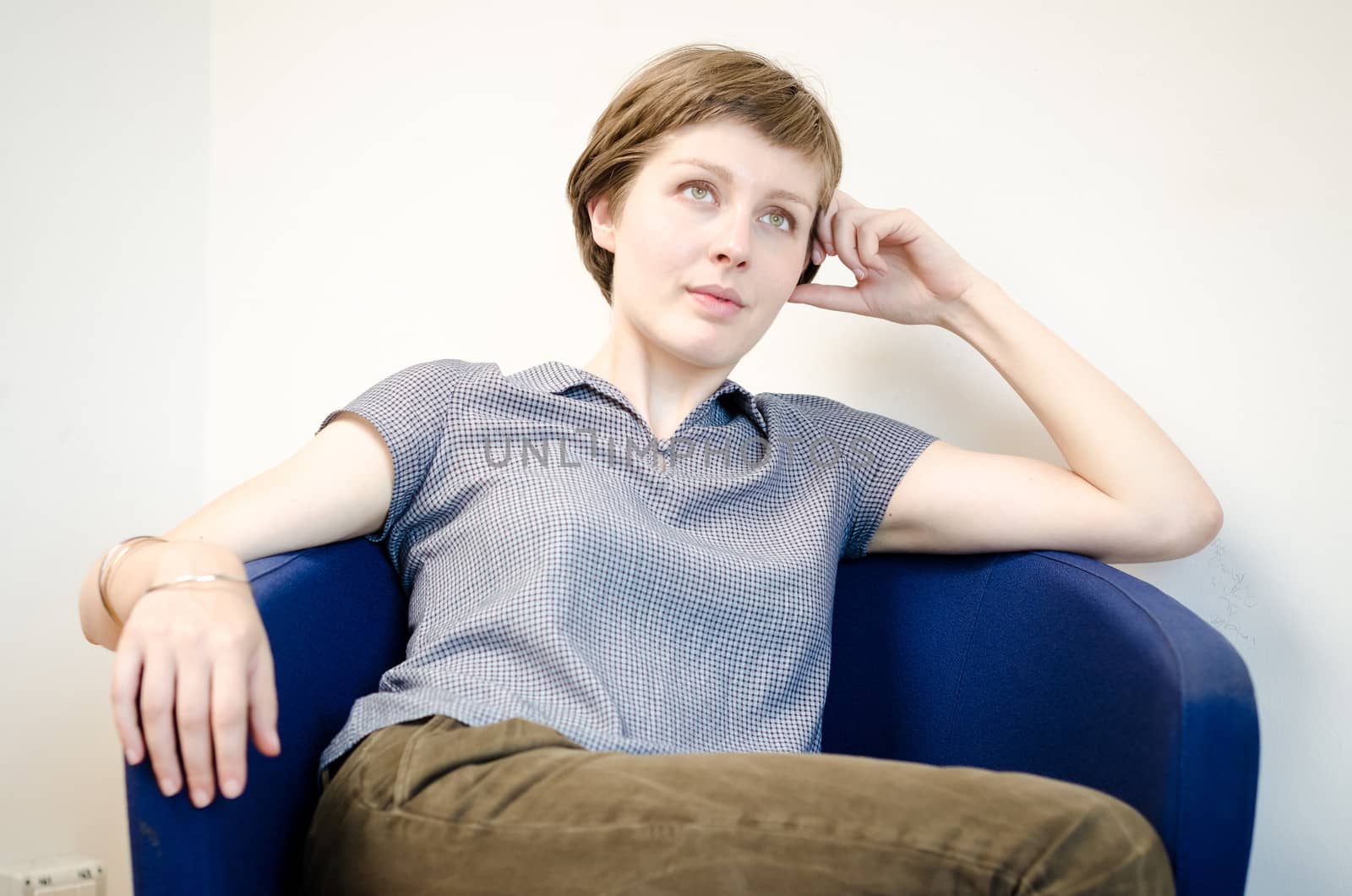 young beautiful hipster woman sitting in the armchair relaxing at home