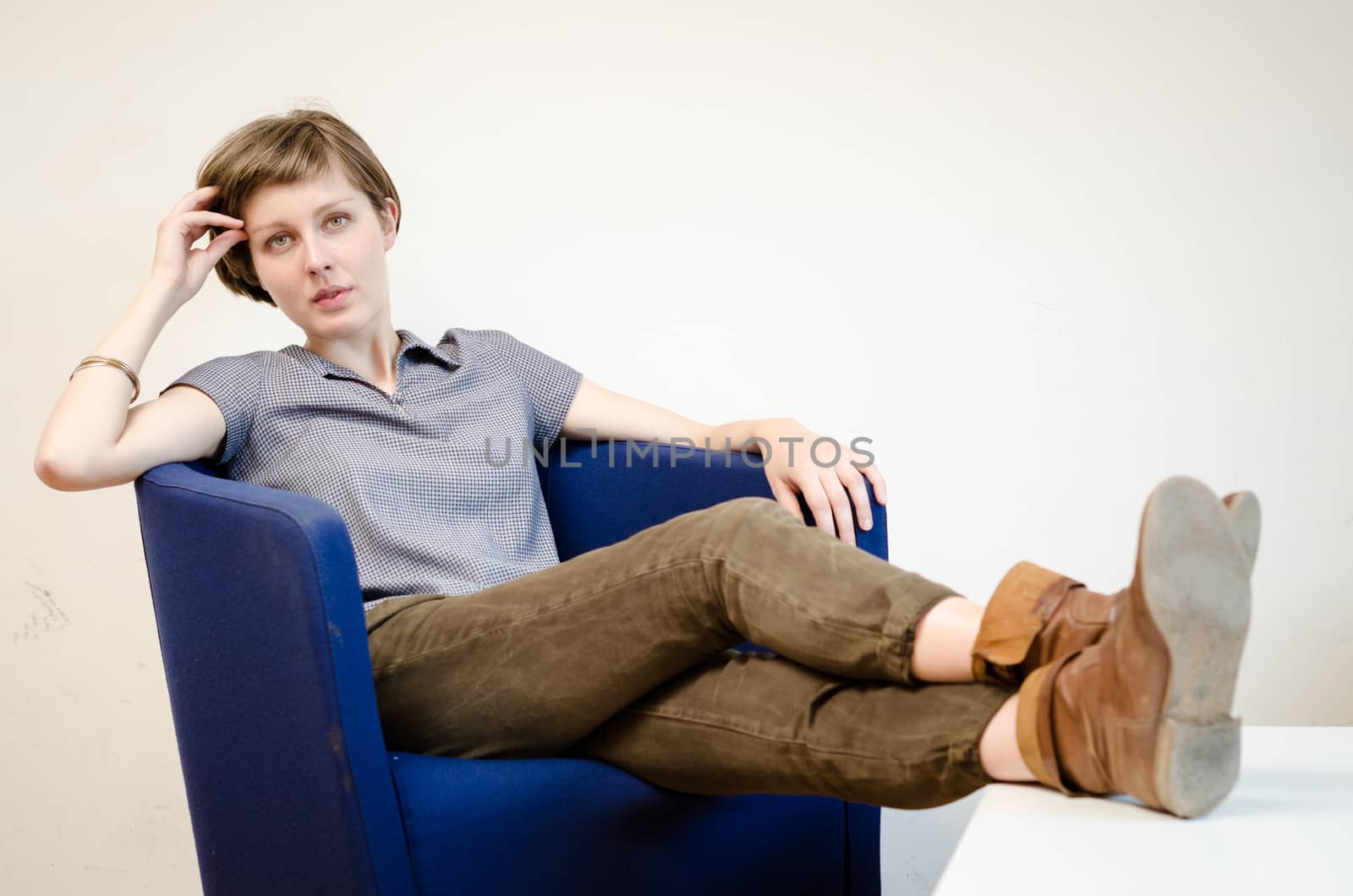 young beautiful hipster woman sitting in the armchair relaxing at home