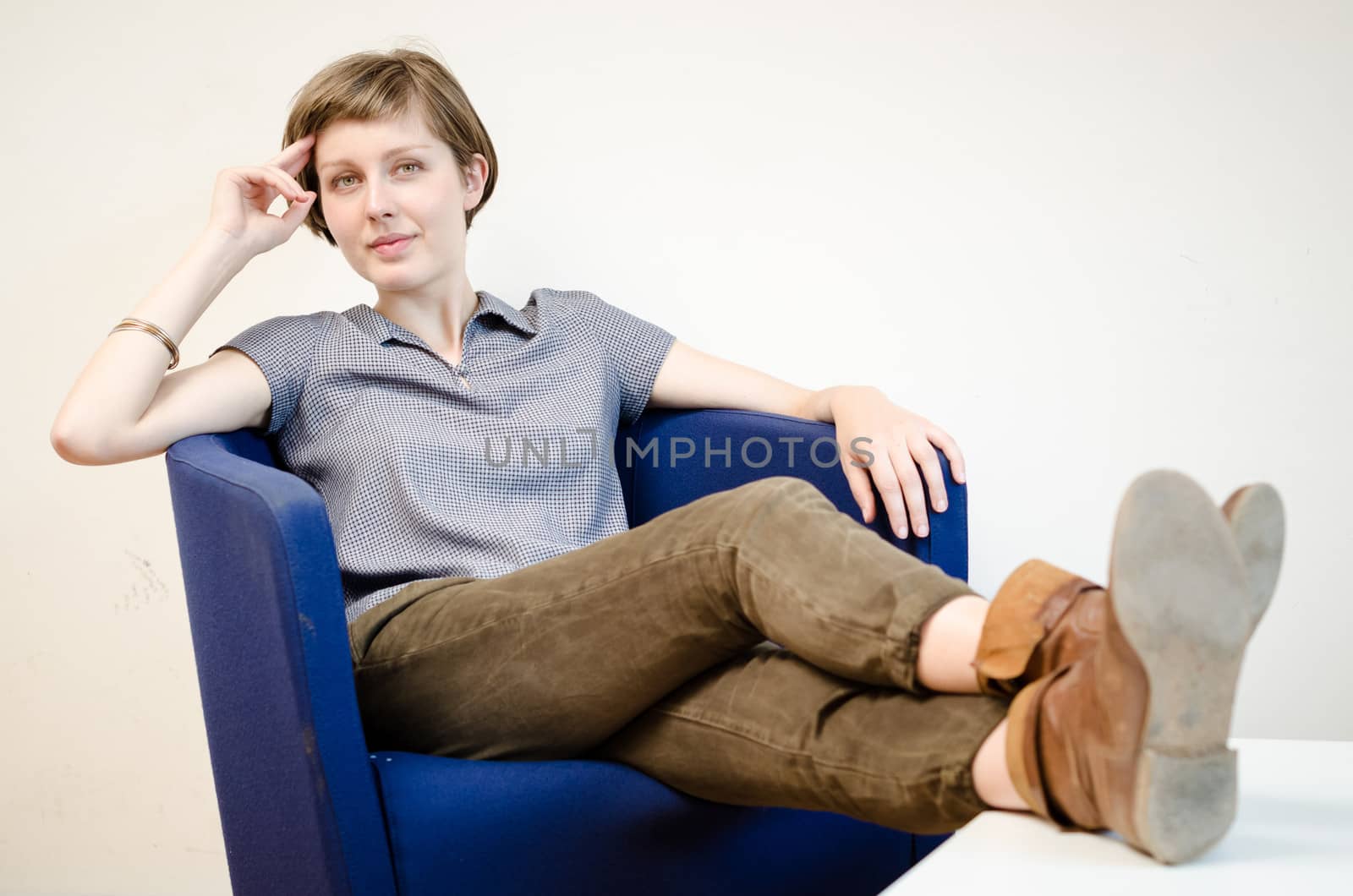young beautiful hipster woman sitting in the armchair relaxing at home