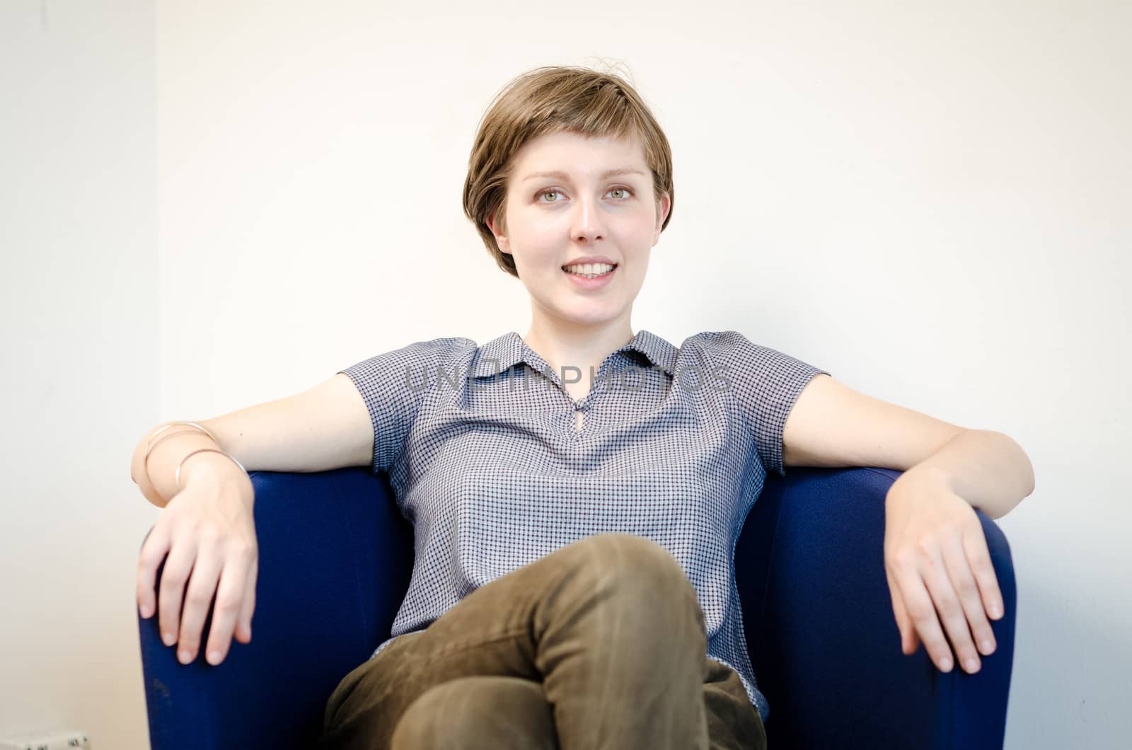young beautiful hipster woman sitting in the armchair relaxing at home