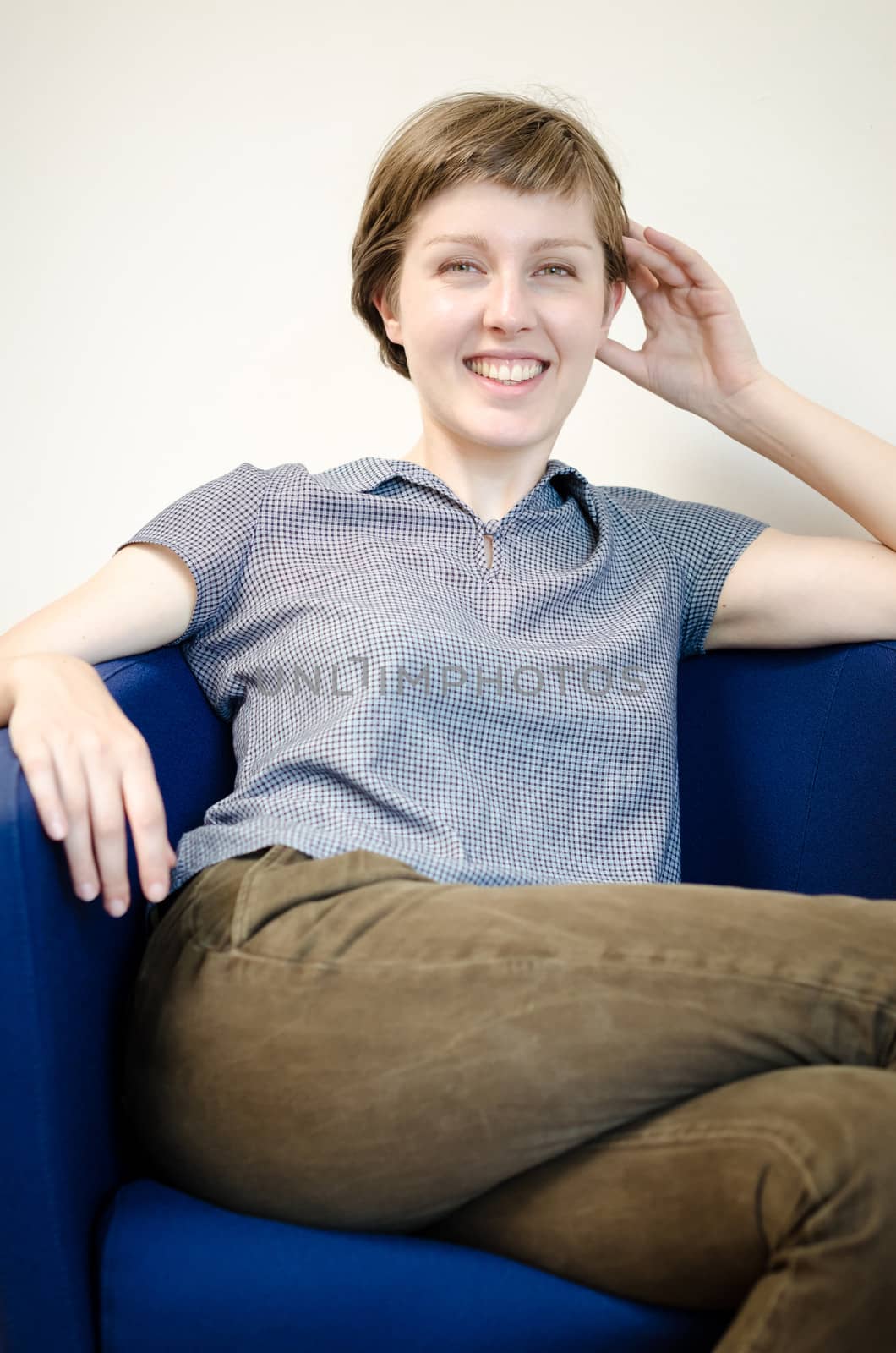 young beautiful hipster woman sitting in the armchair relaxing at home