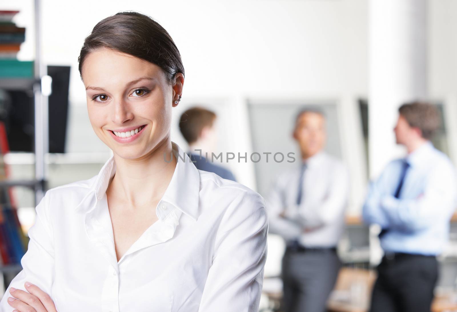 Handsome businesswoman with colleagues in the background