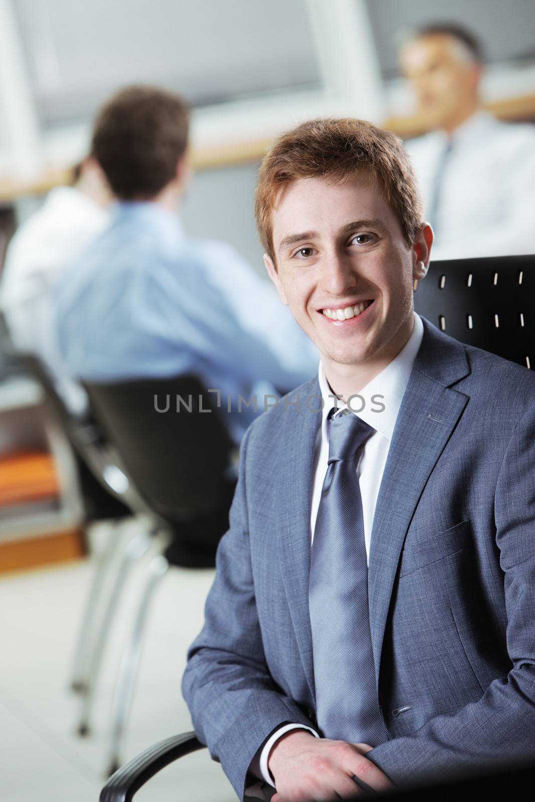Young businessman with colleagues in the background