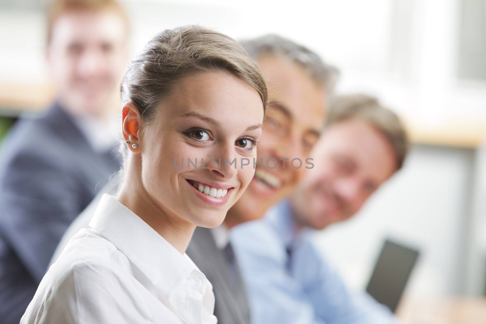 Portrait of a youg smiling business woman and her colleagues