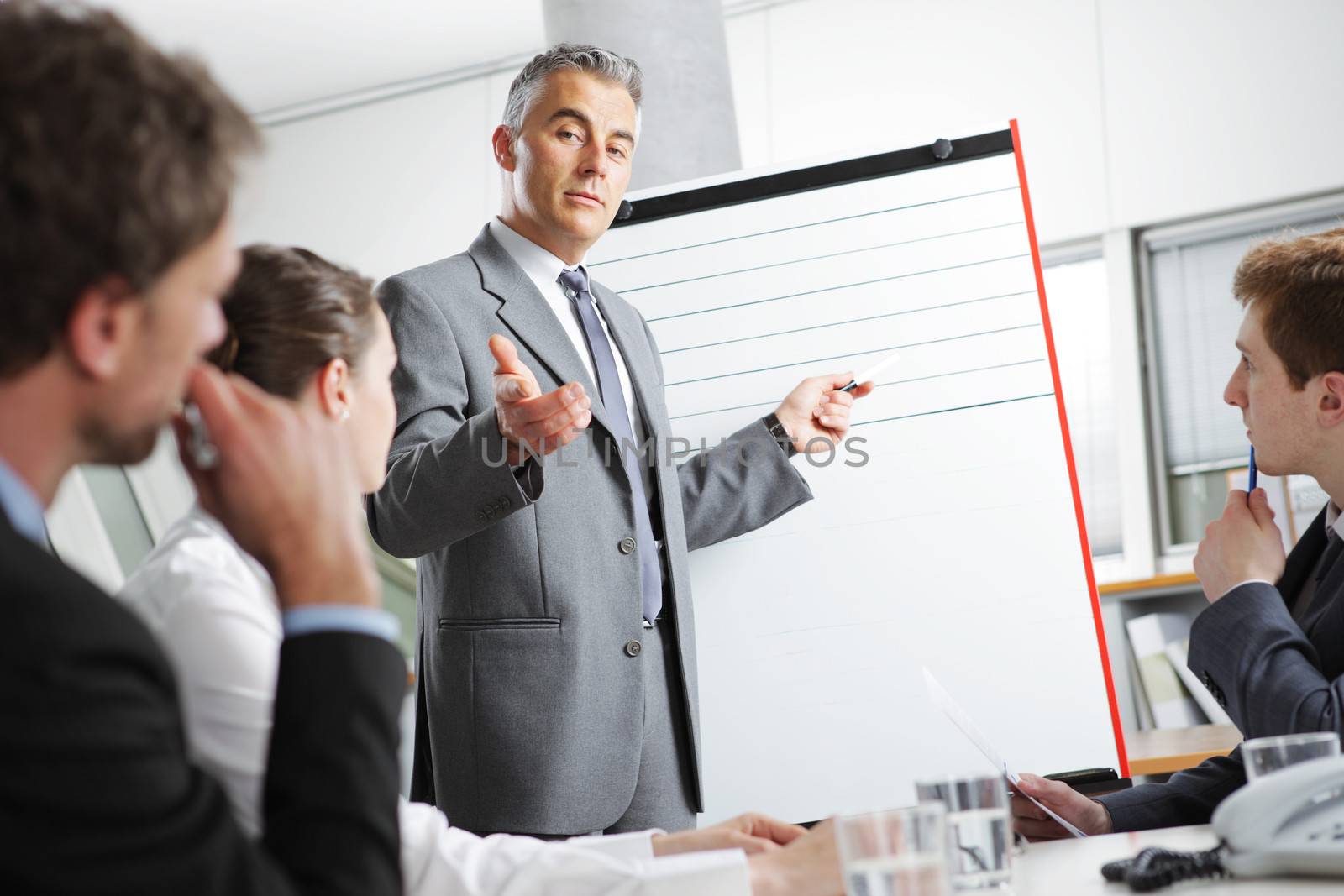 Mature businessman giving a presentation to his colleagues