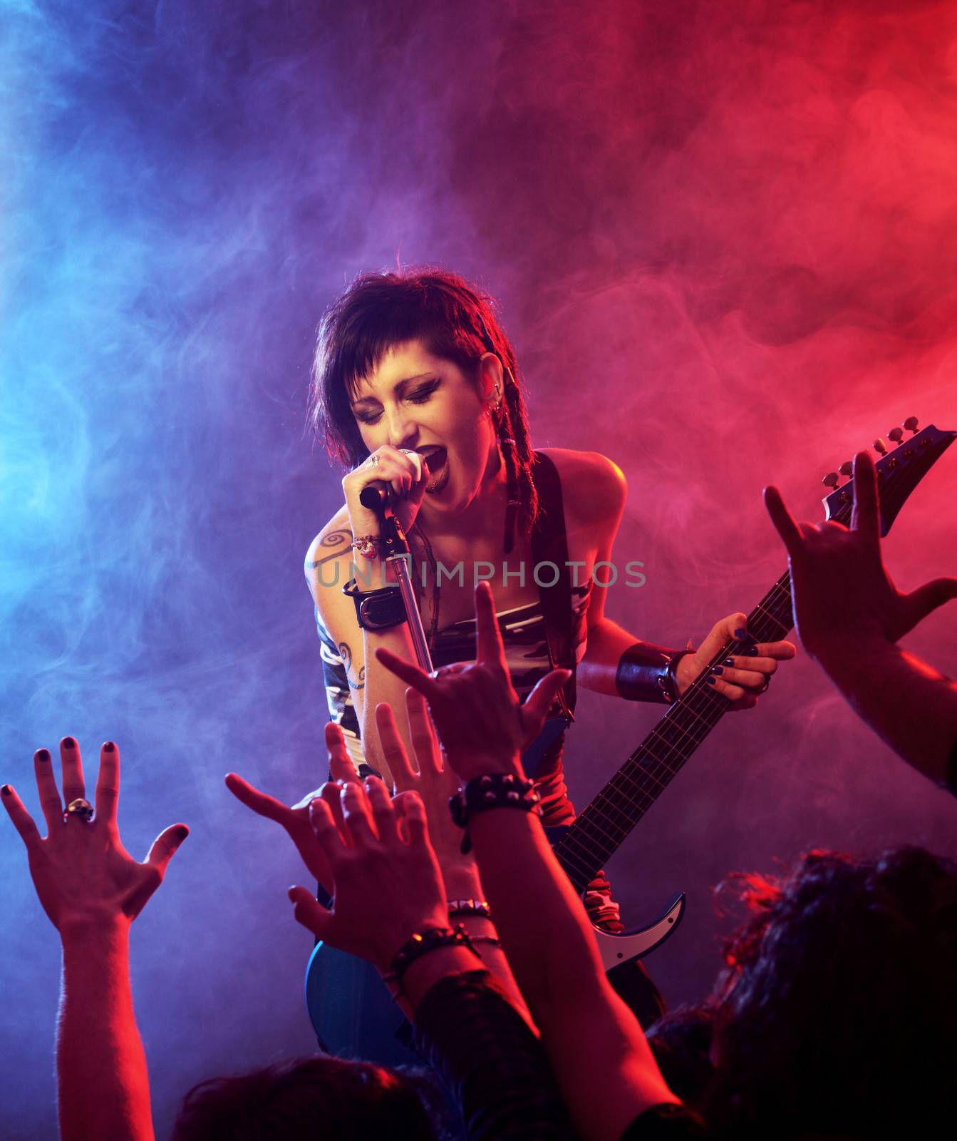 Female singer and guitarist playing guitar at a rock concert
