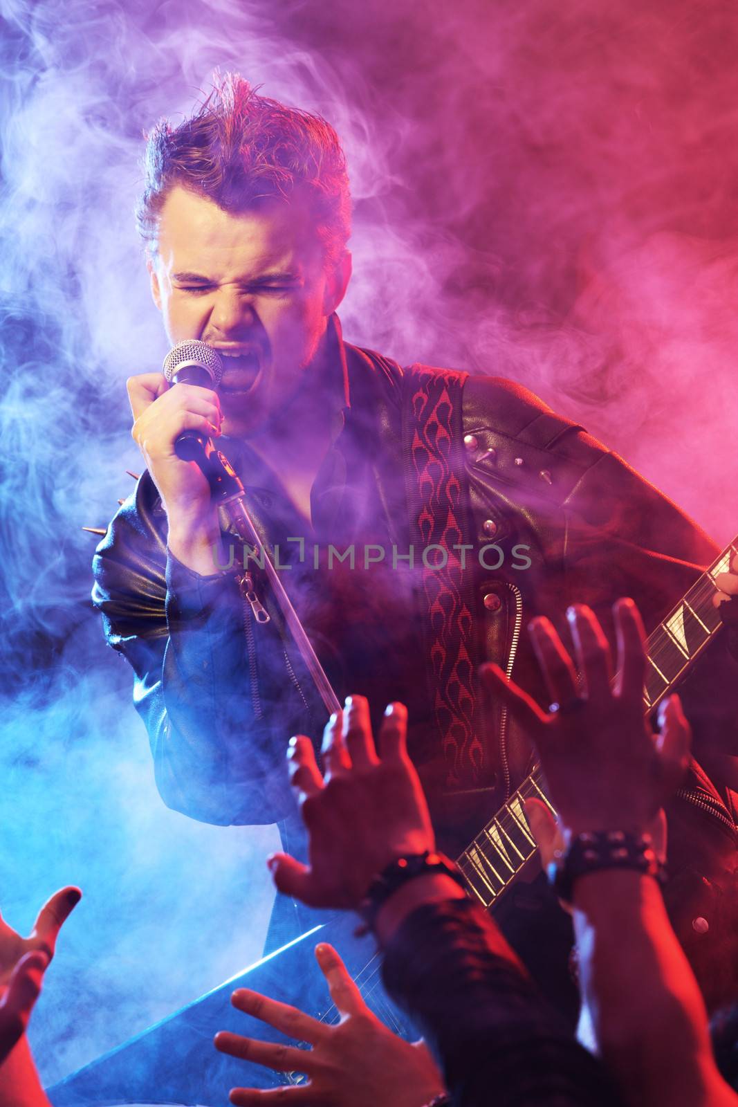 Guitarist singing on stage at a rock concert for his adoring fans