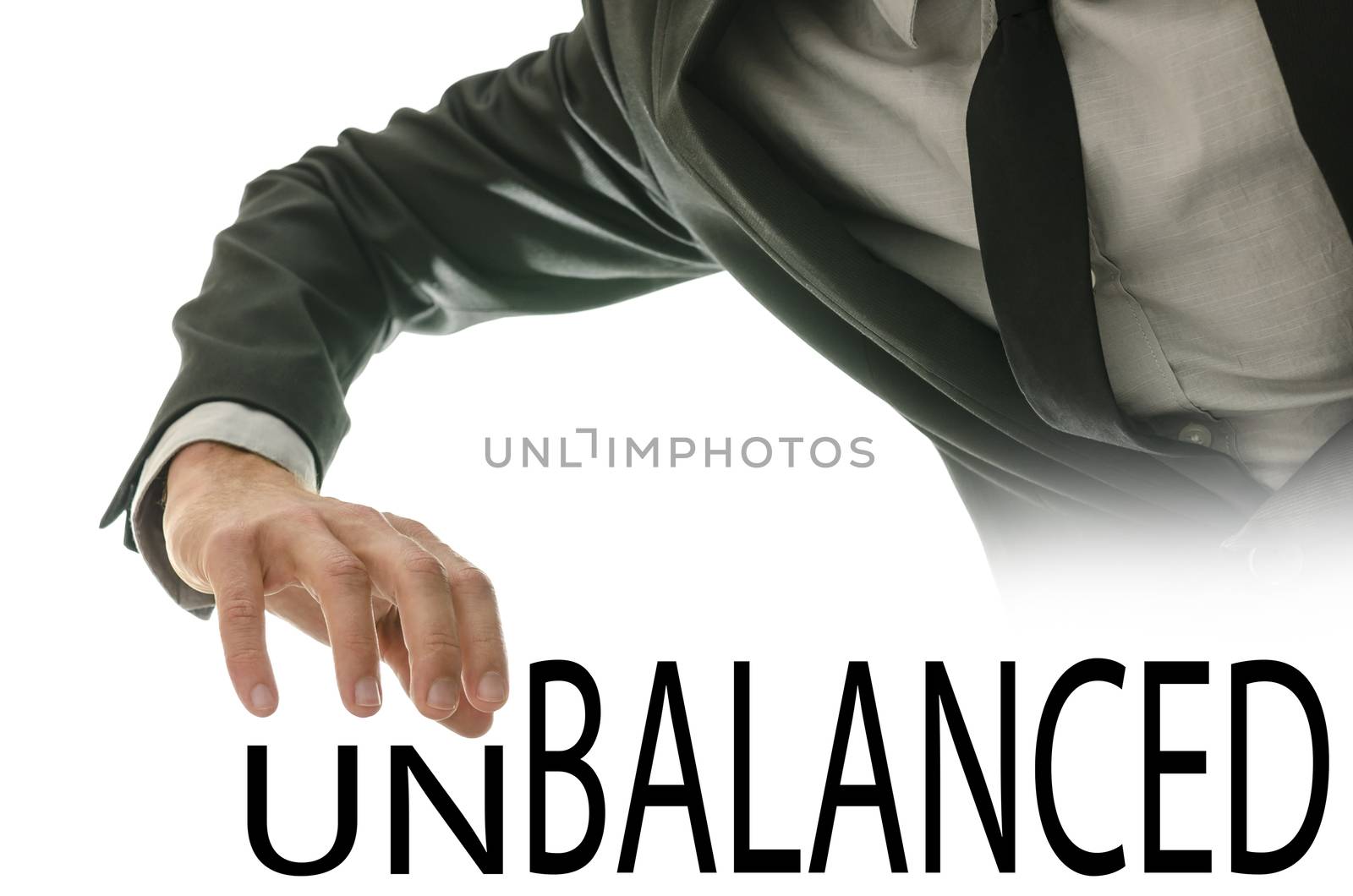 Male hand pushing away letters UN of the word Unbalanced.