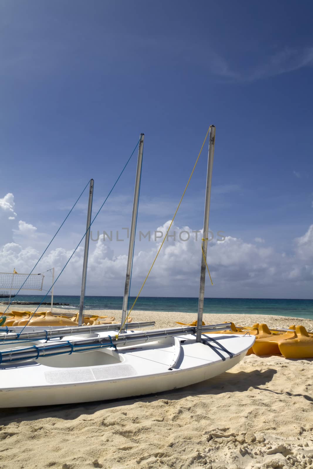 A personal sail boat on the beach by the ocean