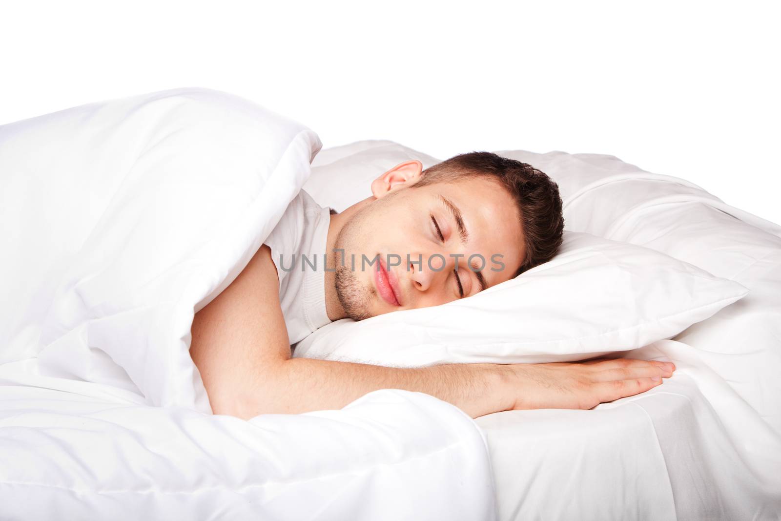 Handsome young man happily sleeping in white bed, isolated.