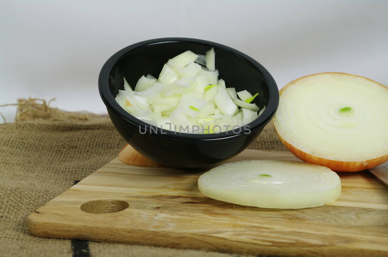 Raw Onion Diced in a black bowl on a bamboo board