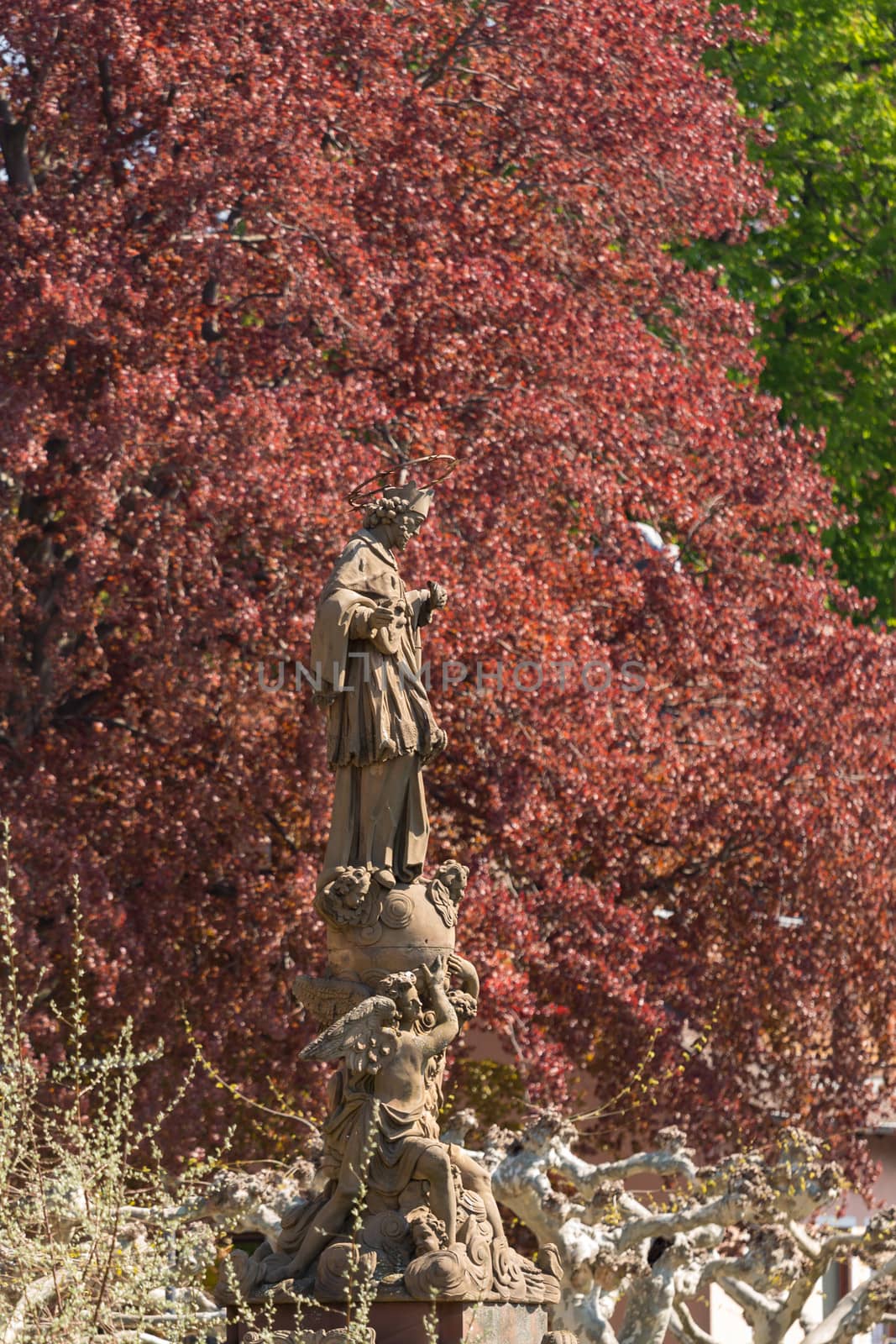 Statue of Saint John of Nepomuk by old bridge leading to ancient town city of Heidelberg Germany