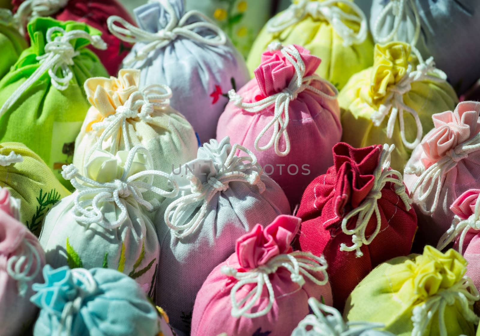 Multi-colored bags of lavender in embroidered gift cloth sacks tied with string
