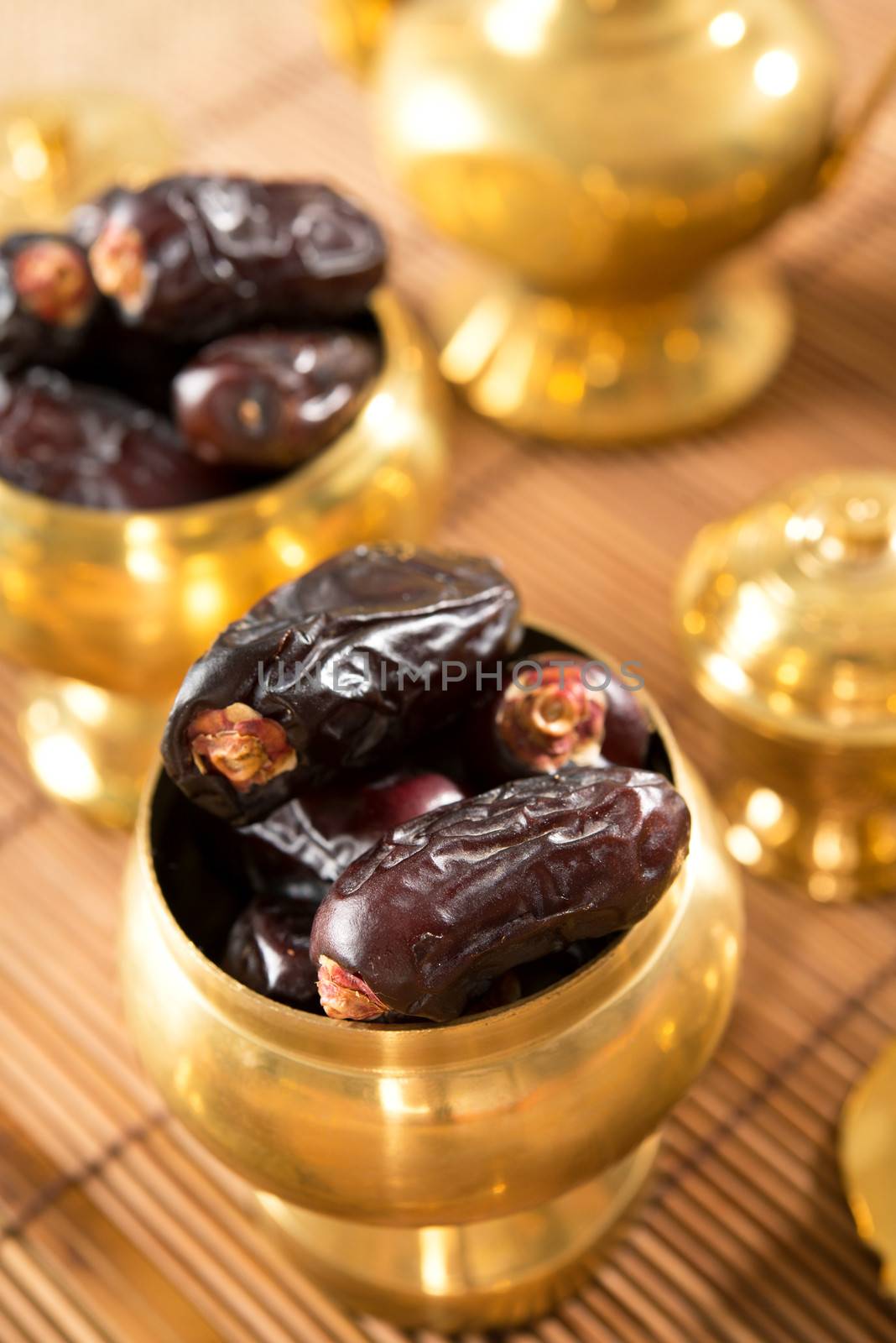 Dates fruit. Pile of fresh dried date fruits in golden metal bowl.