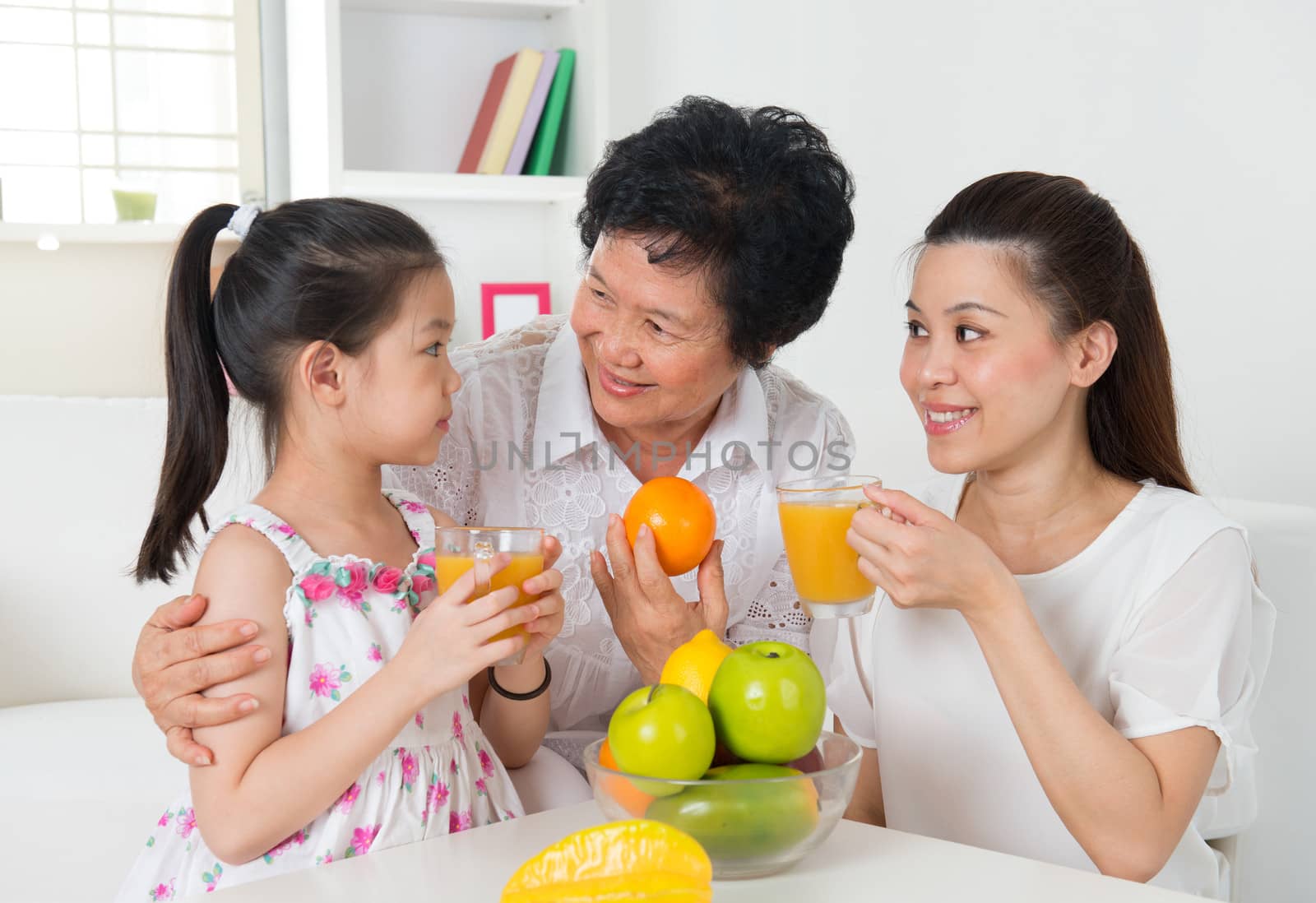 Asian family drinking orange juice.  by szefei