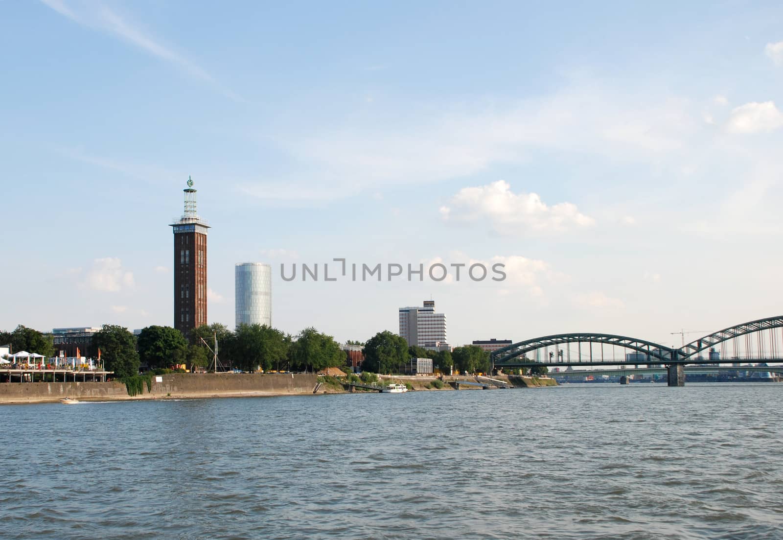 The Messeturm (Fair Tower), Triangle Tower and Hohenzollernbruecke (Hohenzollern Bridge) seen from the Rhine in Cologne, Germany