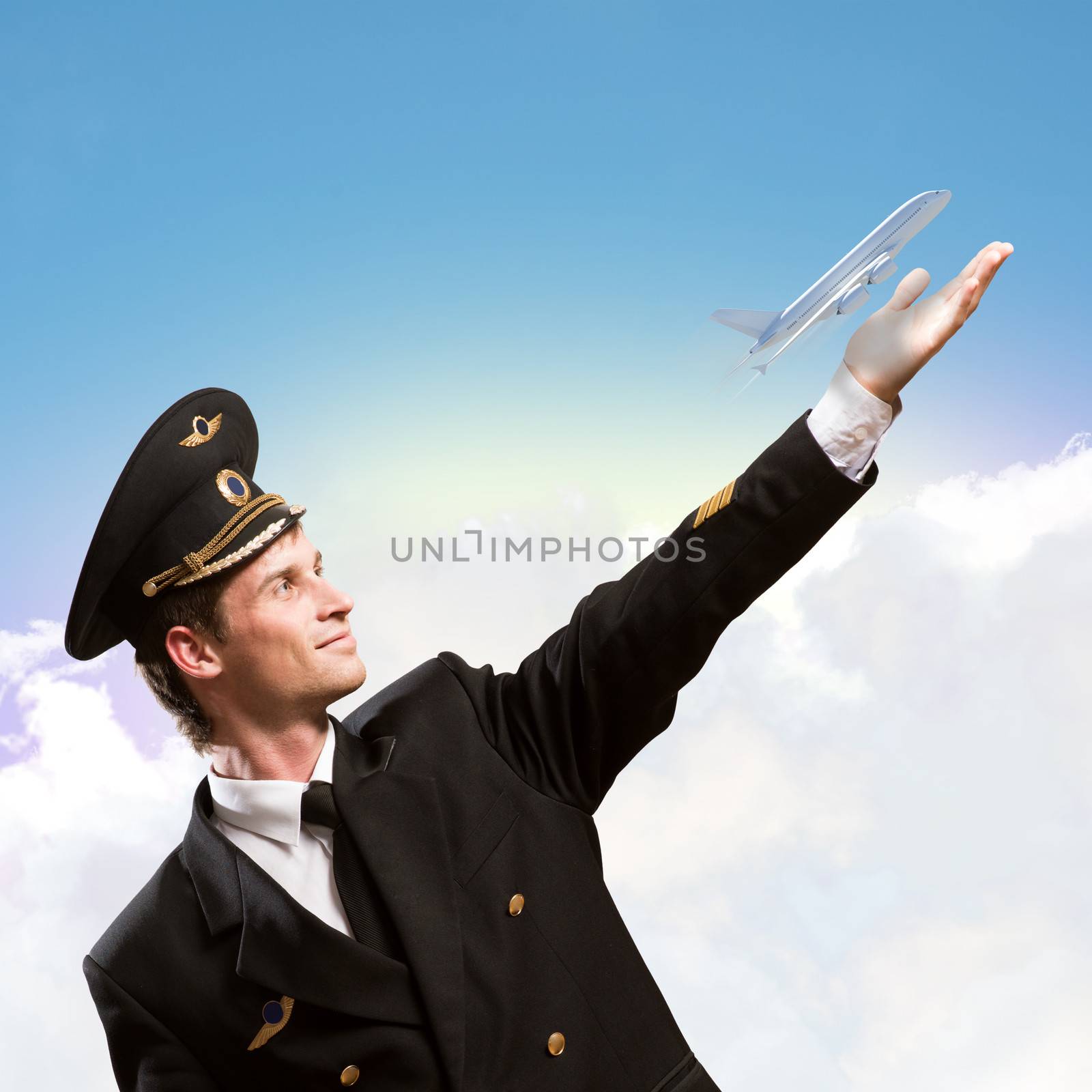 pilot in the form of extending a hand to a flying airplane on the background of sky with clouds