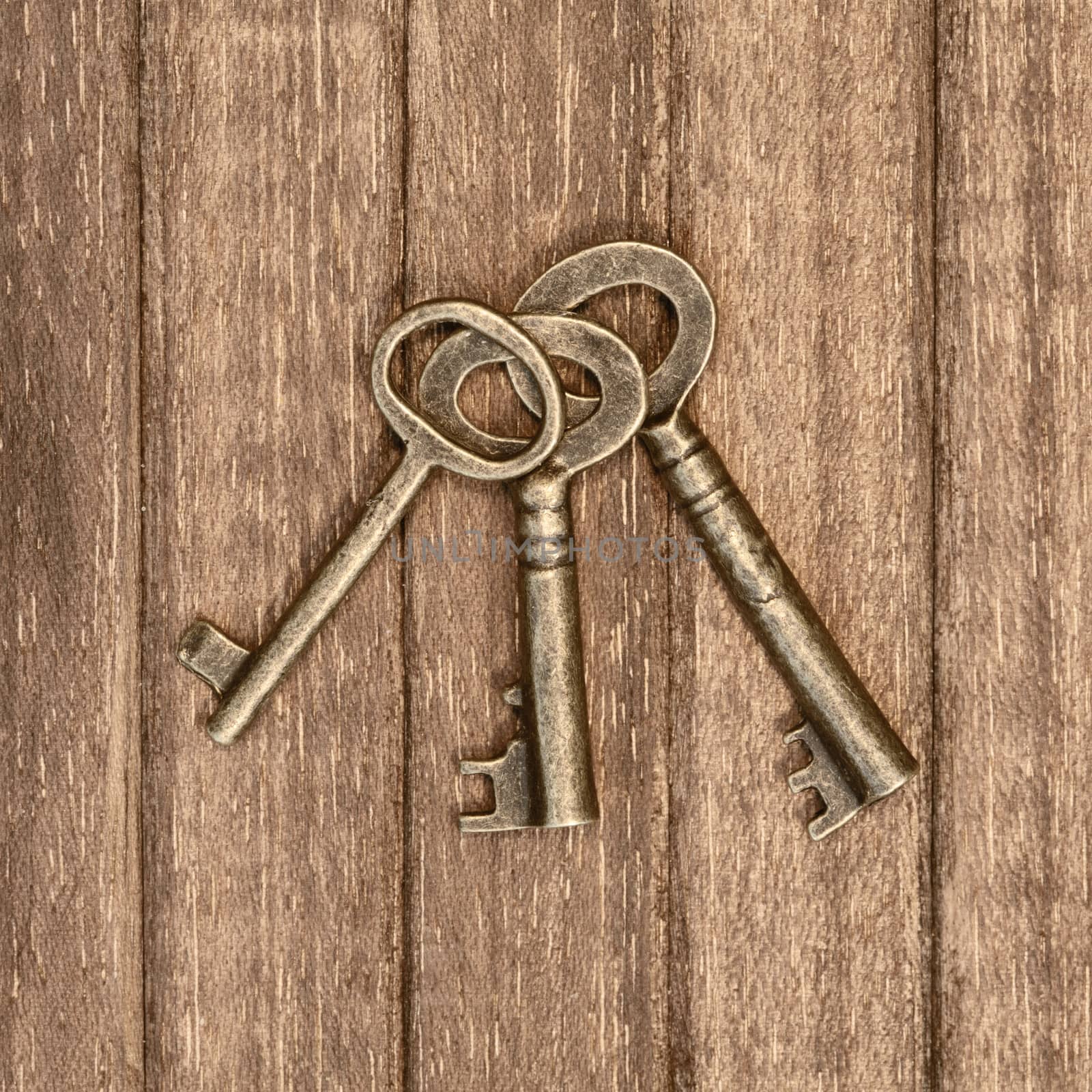 three old keys on a wooden background
