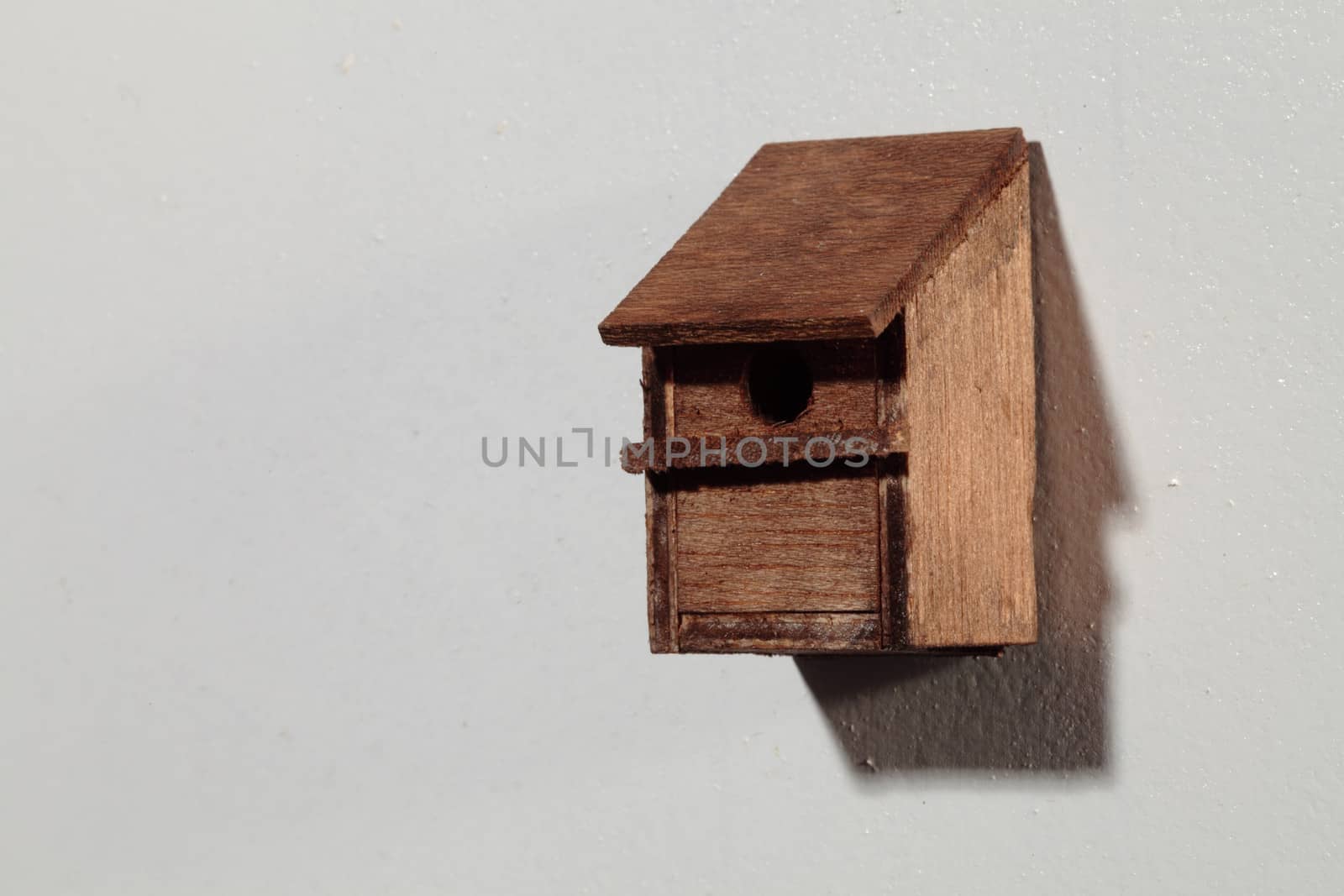 an old and vintage bird house on a white wall