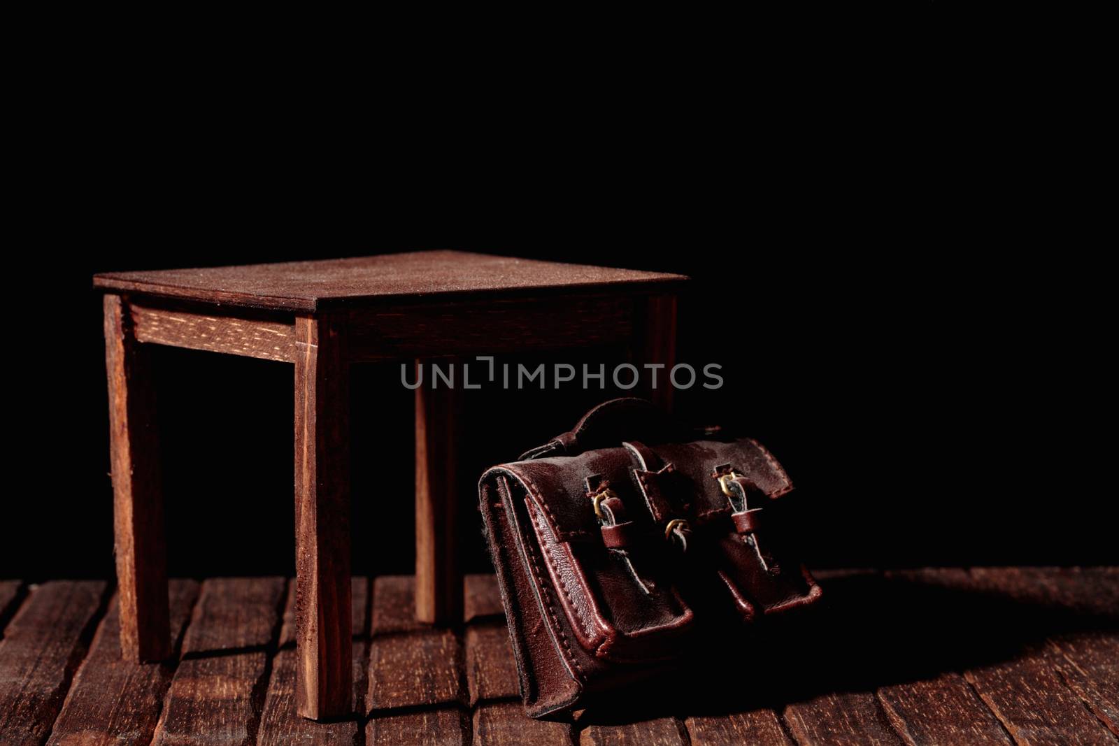 a vintage bag under an old and wooden table