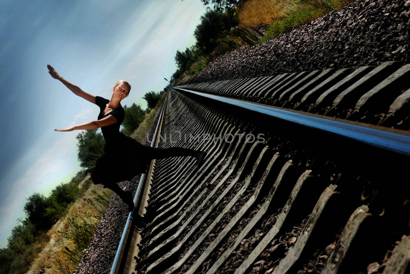 Ballet dancer on the railway in dynamic pose