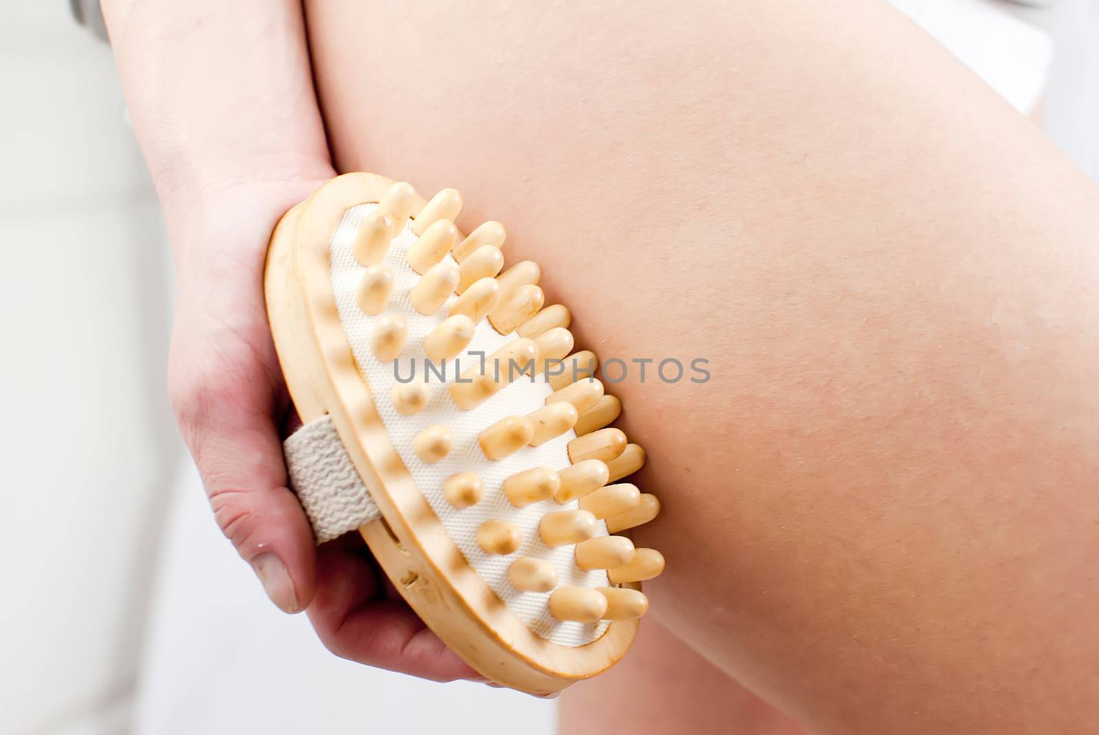 young woman making massage with wooden massager to prevent cellulite