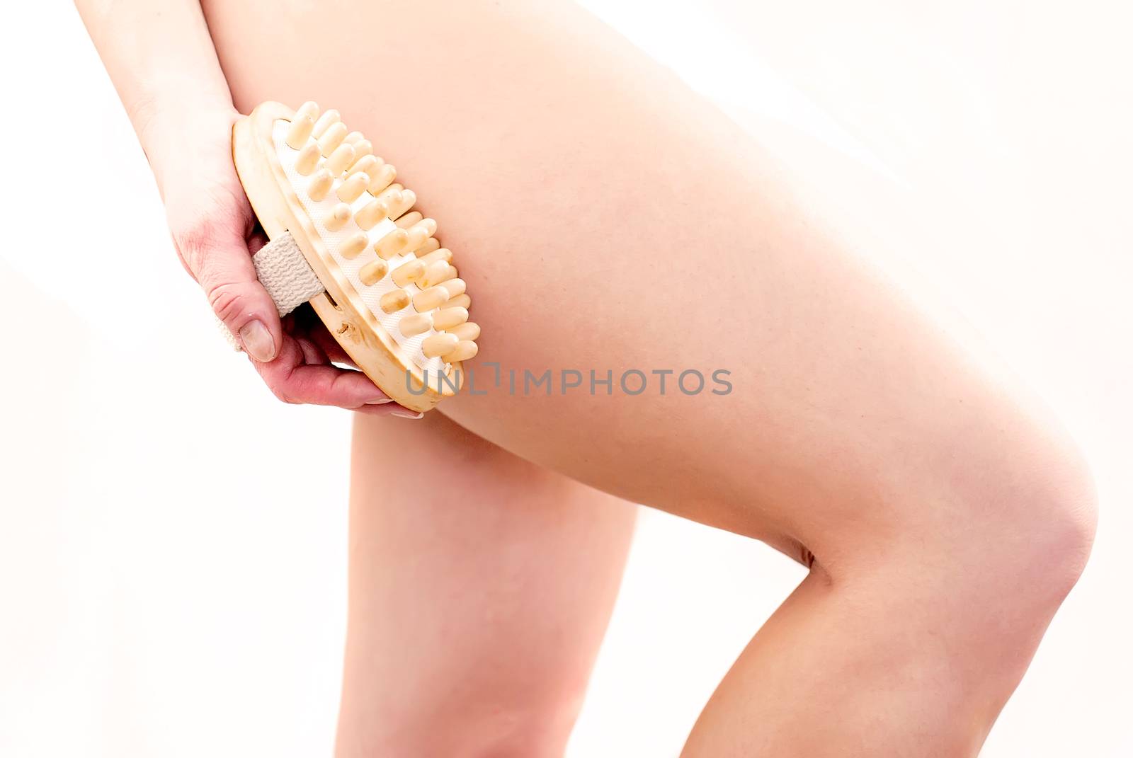 young woman making massage with wooden massager to prevent cellulite