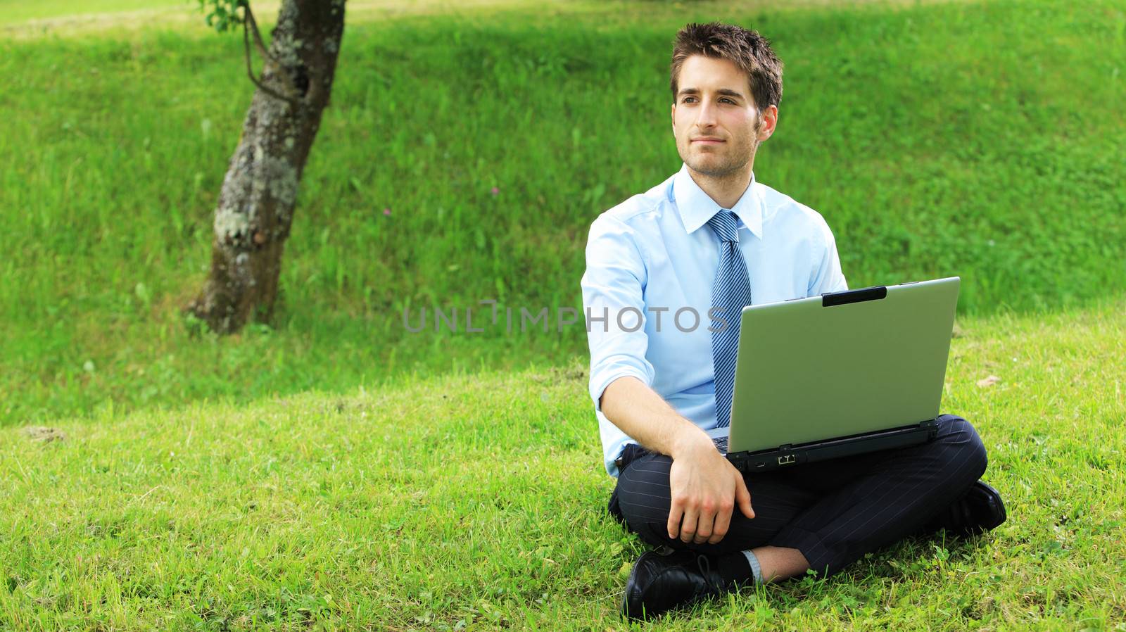 Young business man working on laptop outdoors
