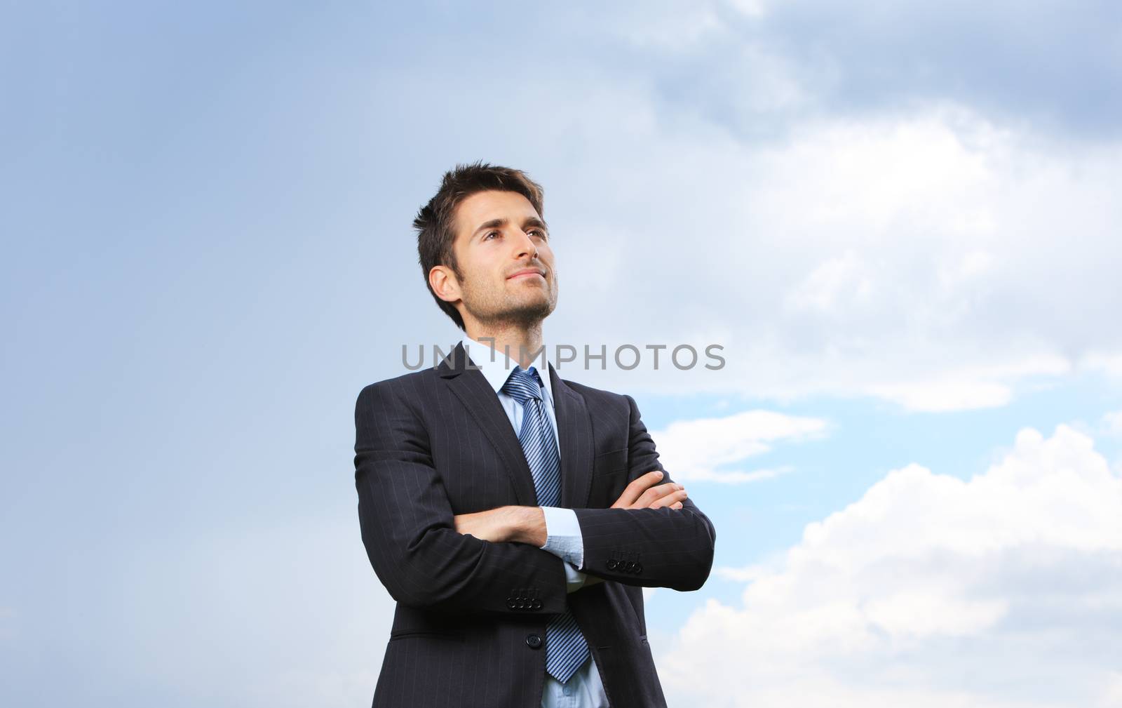 Portrait of a young business man on sky background