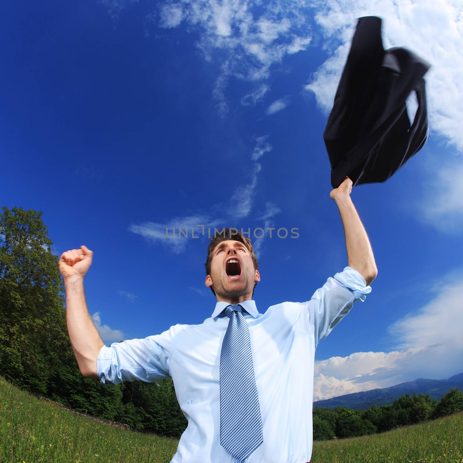 Young business man celebrating his success with arms raised. Fisheye lens used