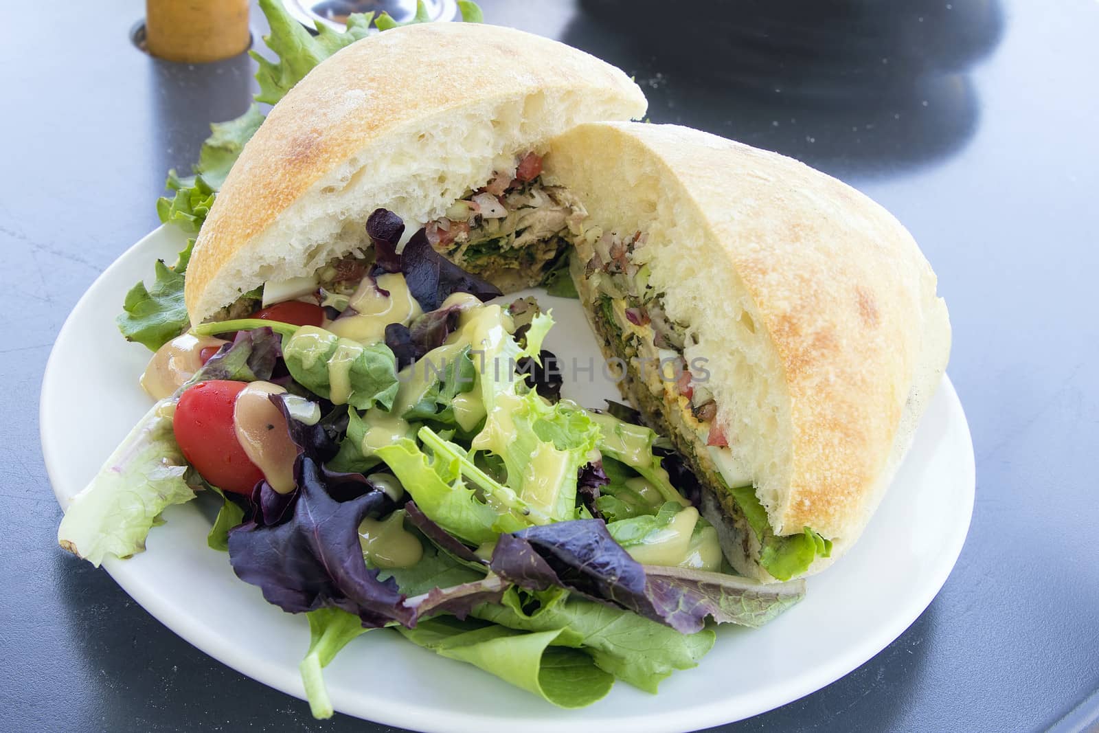 Tuna Salad Sandwich with Ciabatta Bread and Leafy Mixed Green Salad with Tomatoes Closeup