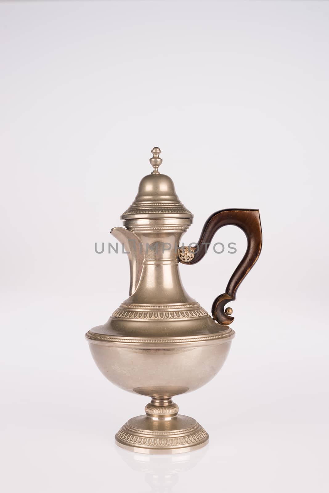 Old teapot with wooden handle isolated on white