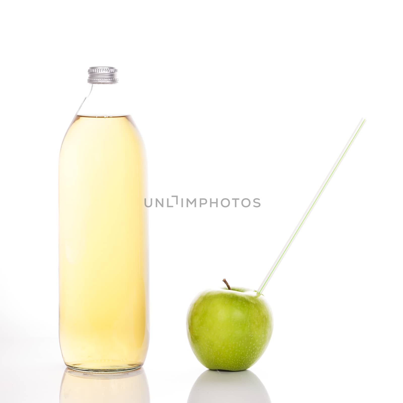 Apple juice in a glass bottle and green apple with straw