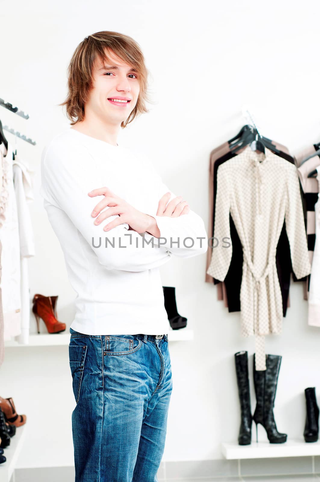 man in shop of clothes, smiles and is happy with purchases