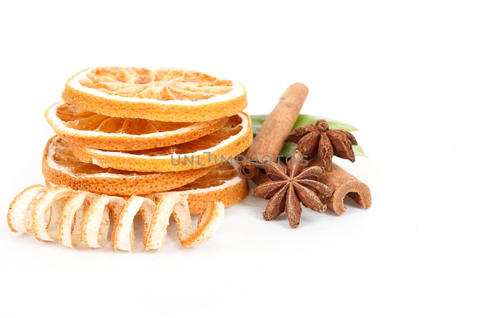 Dried orange, Star Anise, cinnamon and and green leave on white background