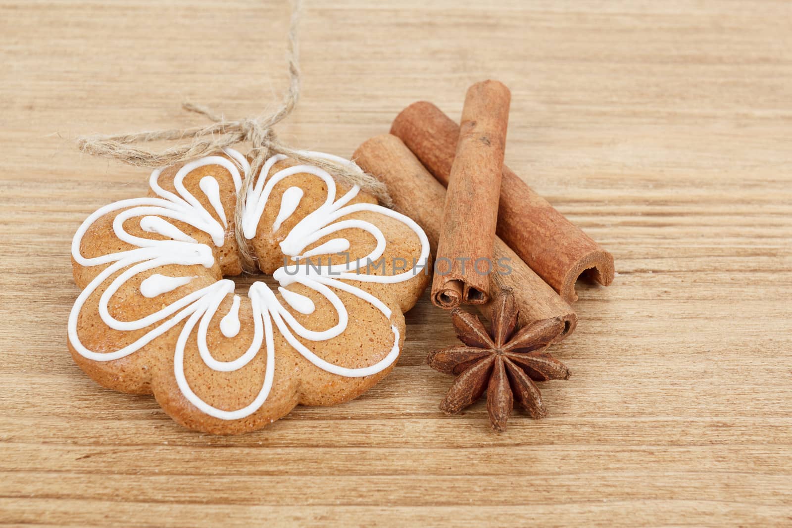 Gingerbread cookies hanging over wooden background with anise and cinamon