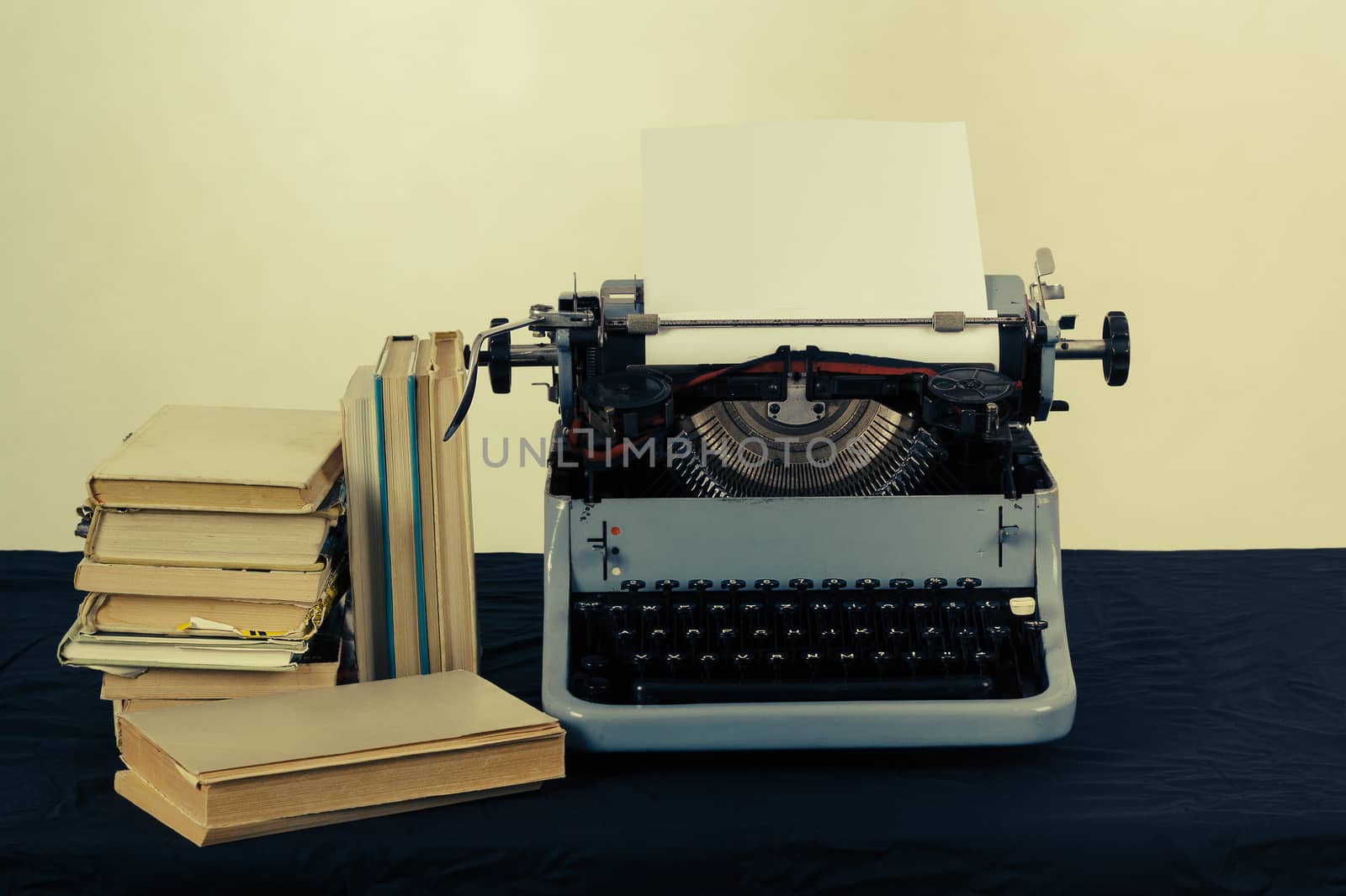 Old typewriter with paper and books, retro colors on the desk