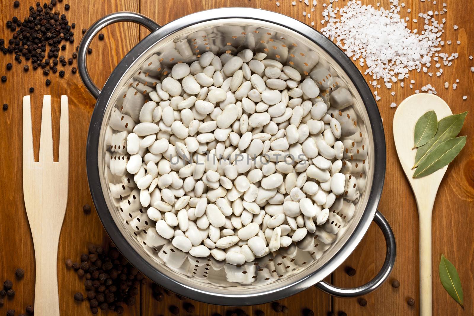 White beans with spices on wooden table background. Food composition. Top view