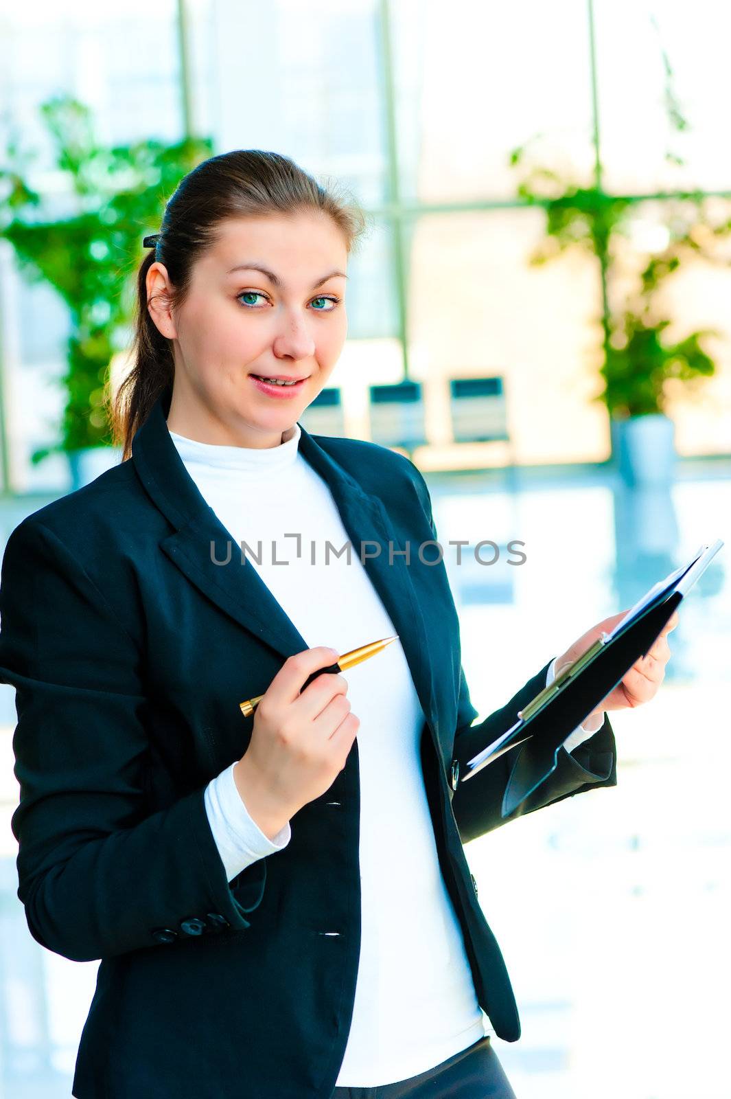 Young happy business woman with a folder and pen in hand by kosmsos111