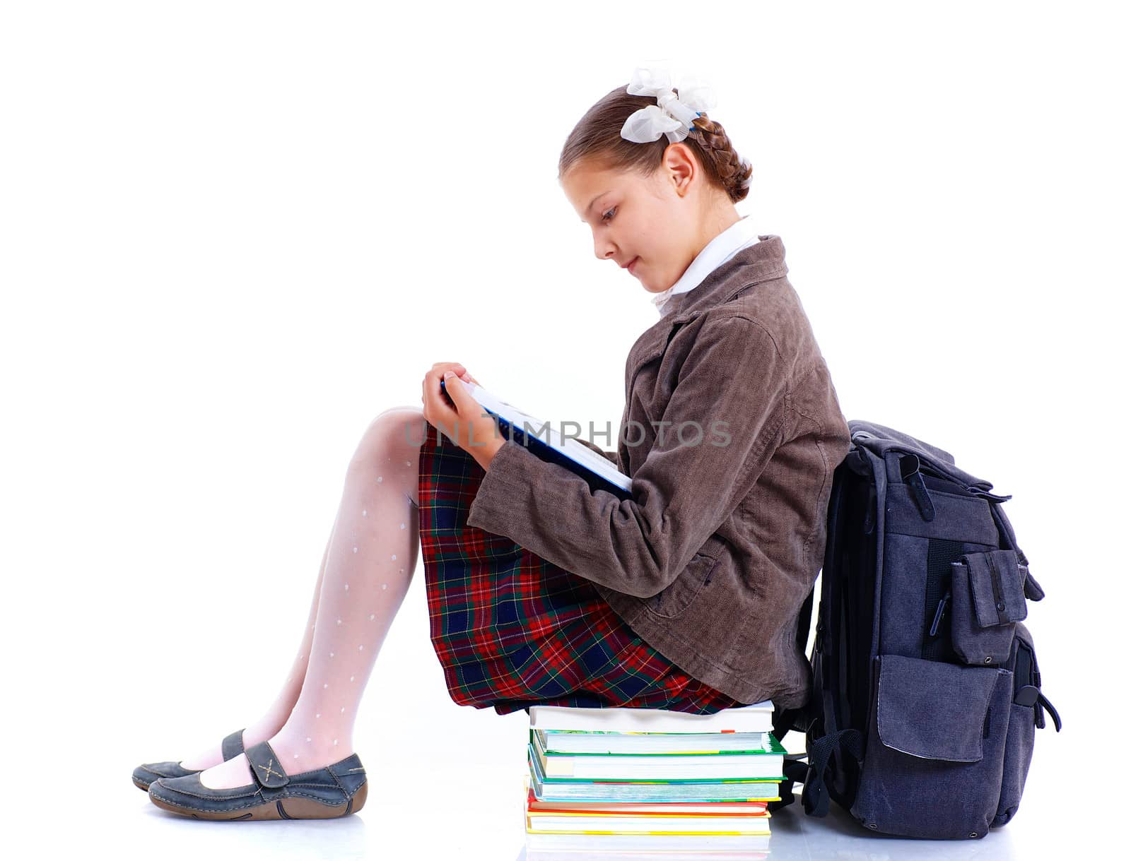Education theme. Joyful schoolgirl smiling happily with backpack and book