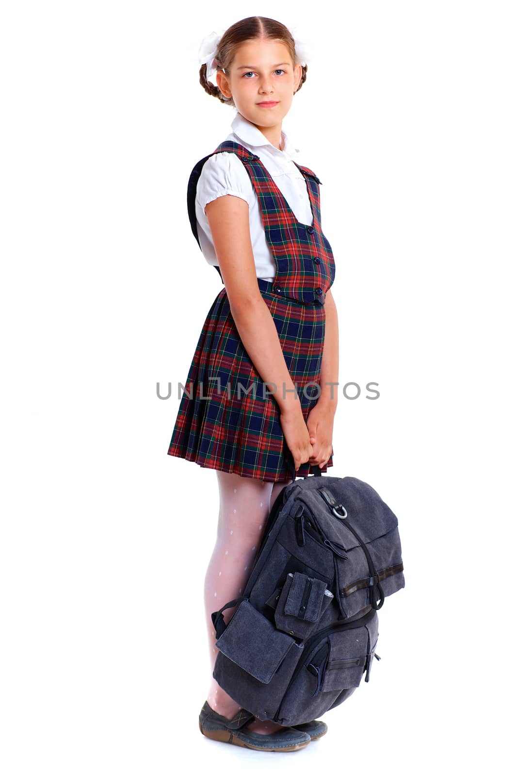 Education theme. Joyful schoolgirl smiling happily with heavy backpack. Isolated on white background