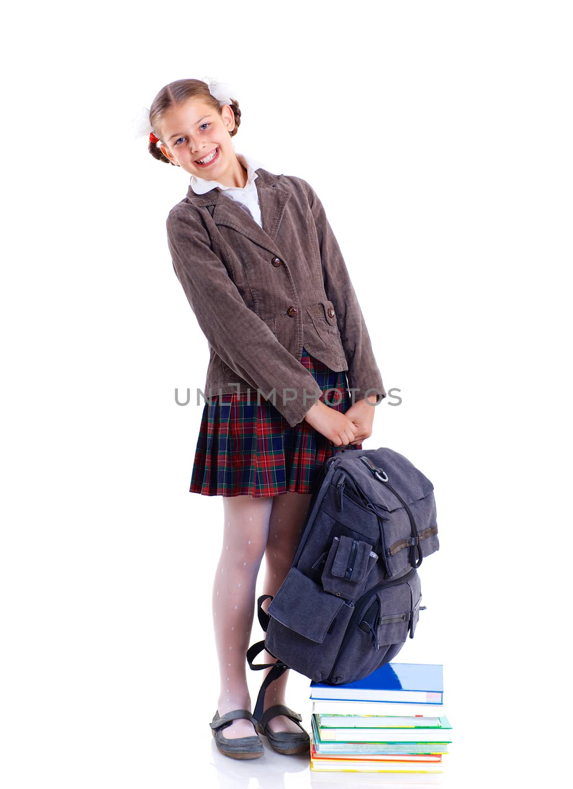 Education theme. Joyful schoolgirl smiling happily with heavy backpack and book. Isolated on white background