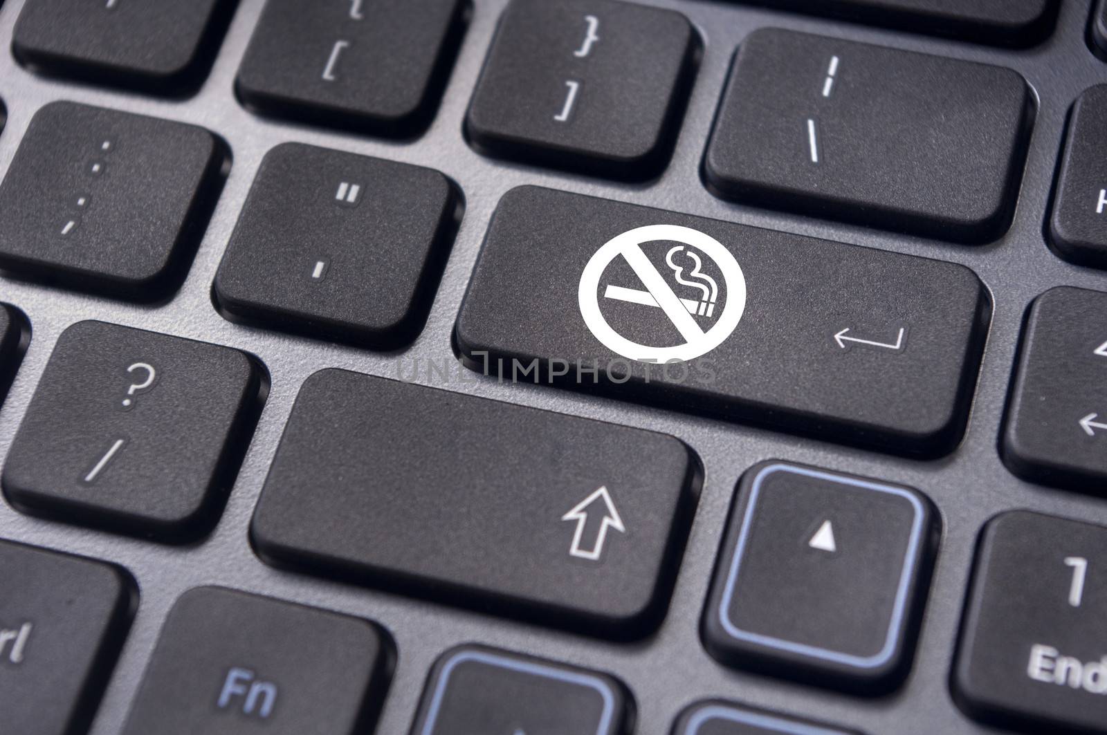 a no smoking sign on keyboard enter key, to convey anti smoking concepts in workplaces or offices.