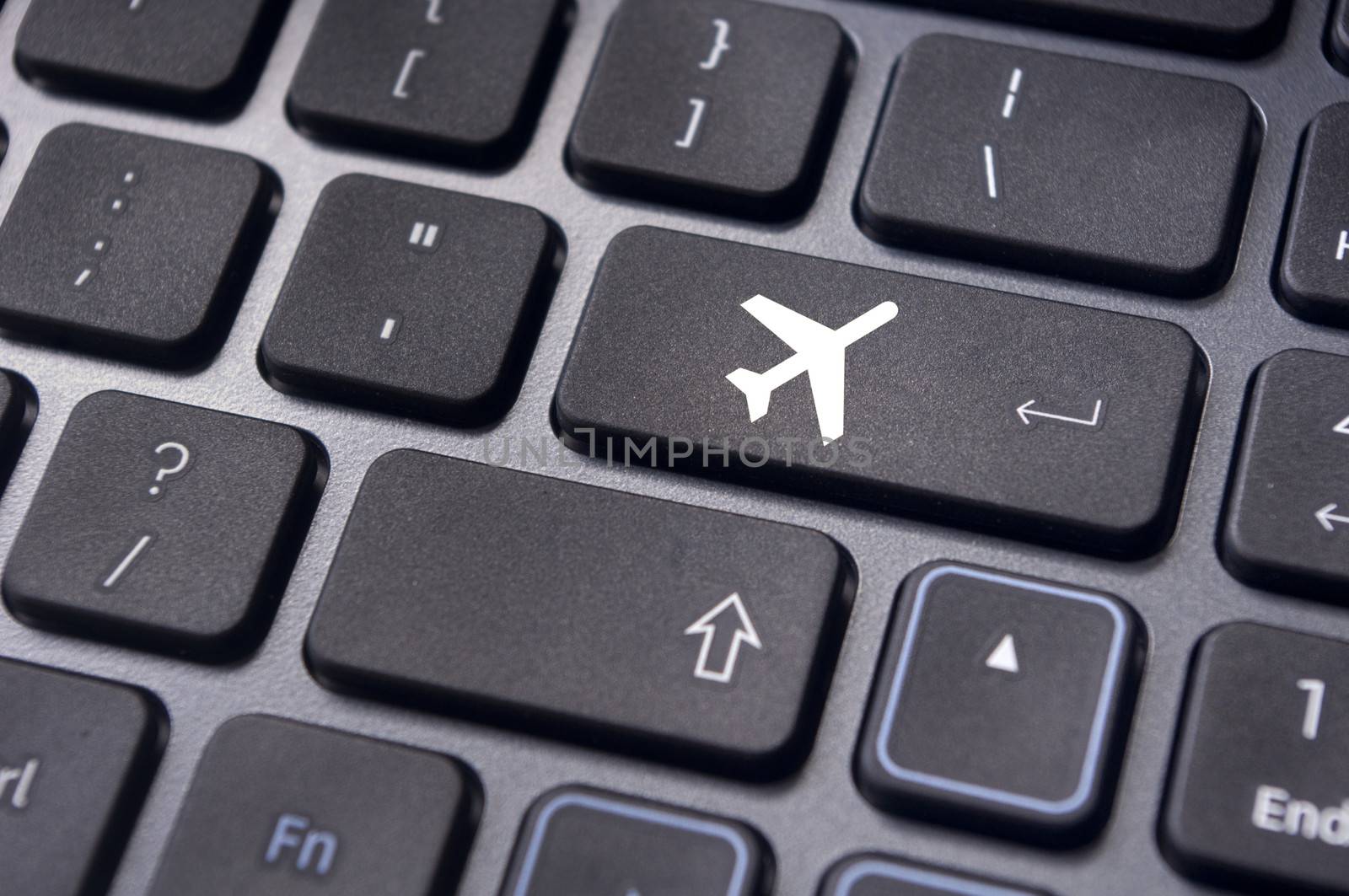 a plane sign on keyboard, to illustrate online booking or purchase of plane ticket or business travel concepts.
